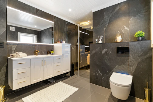 A bathroom with a toilet, sink, and mirror