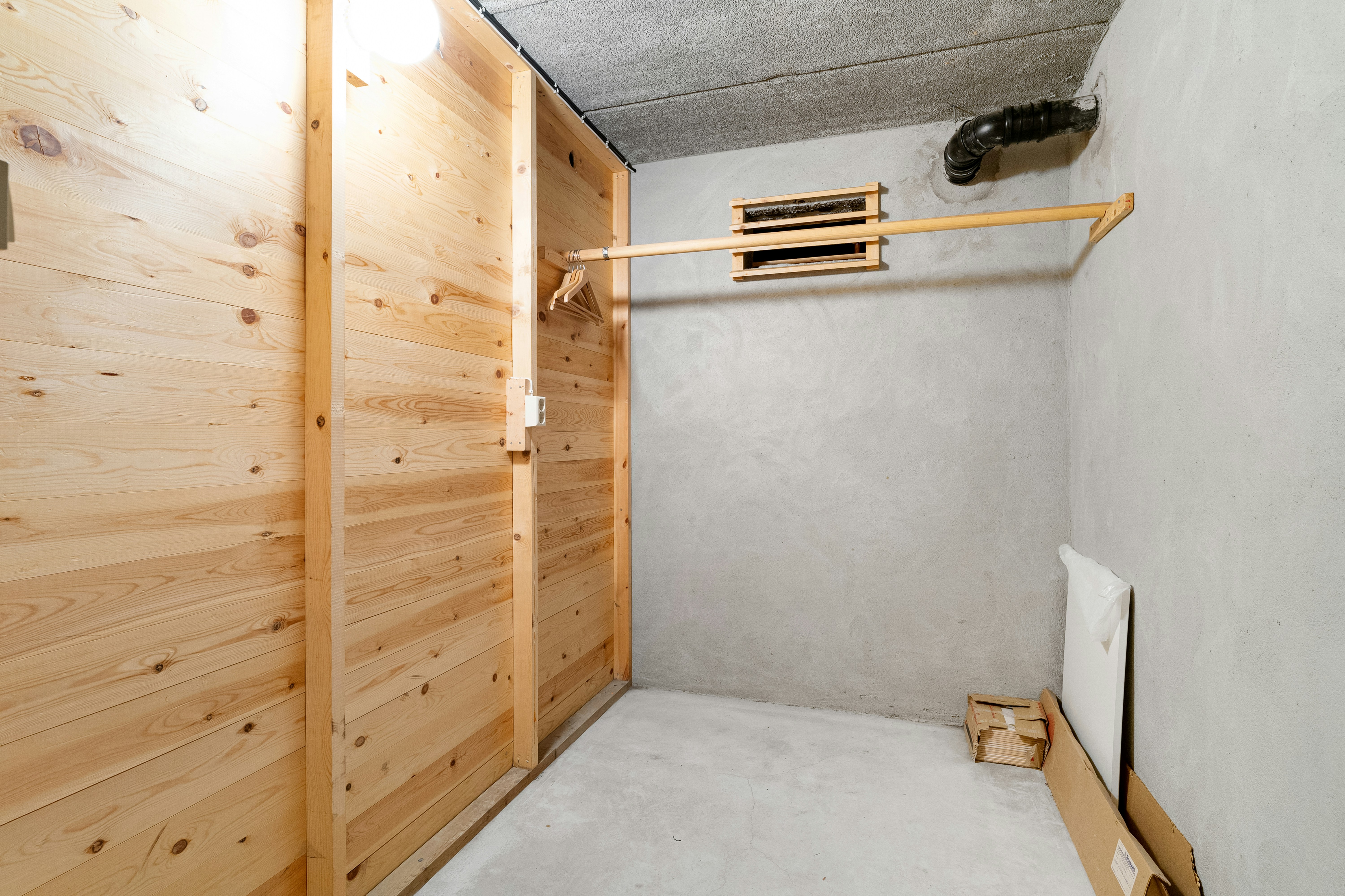 A room with a wooden wall and a white bed