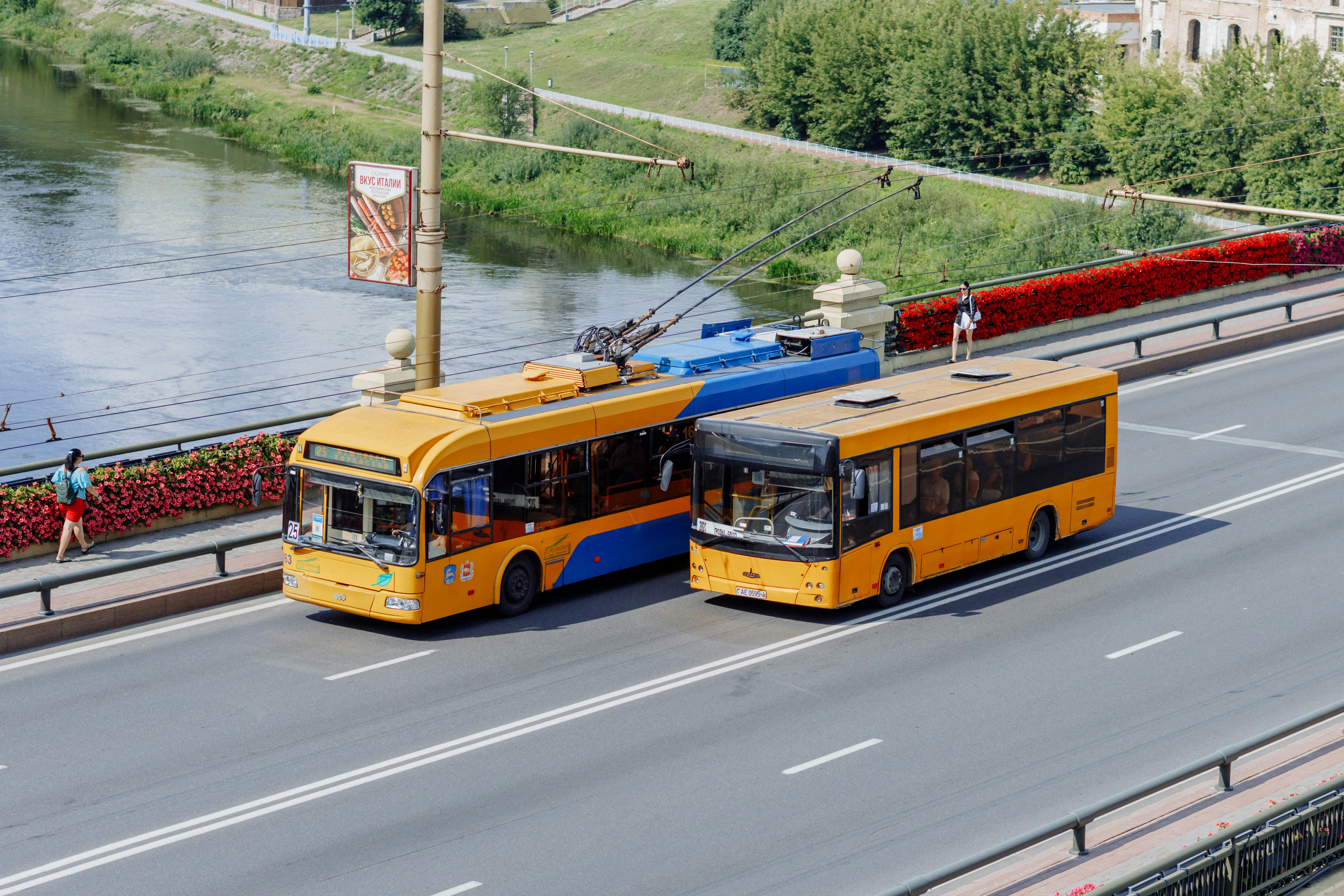 A couple of yellow buses driving down a street