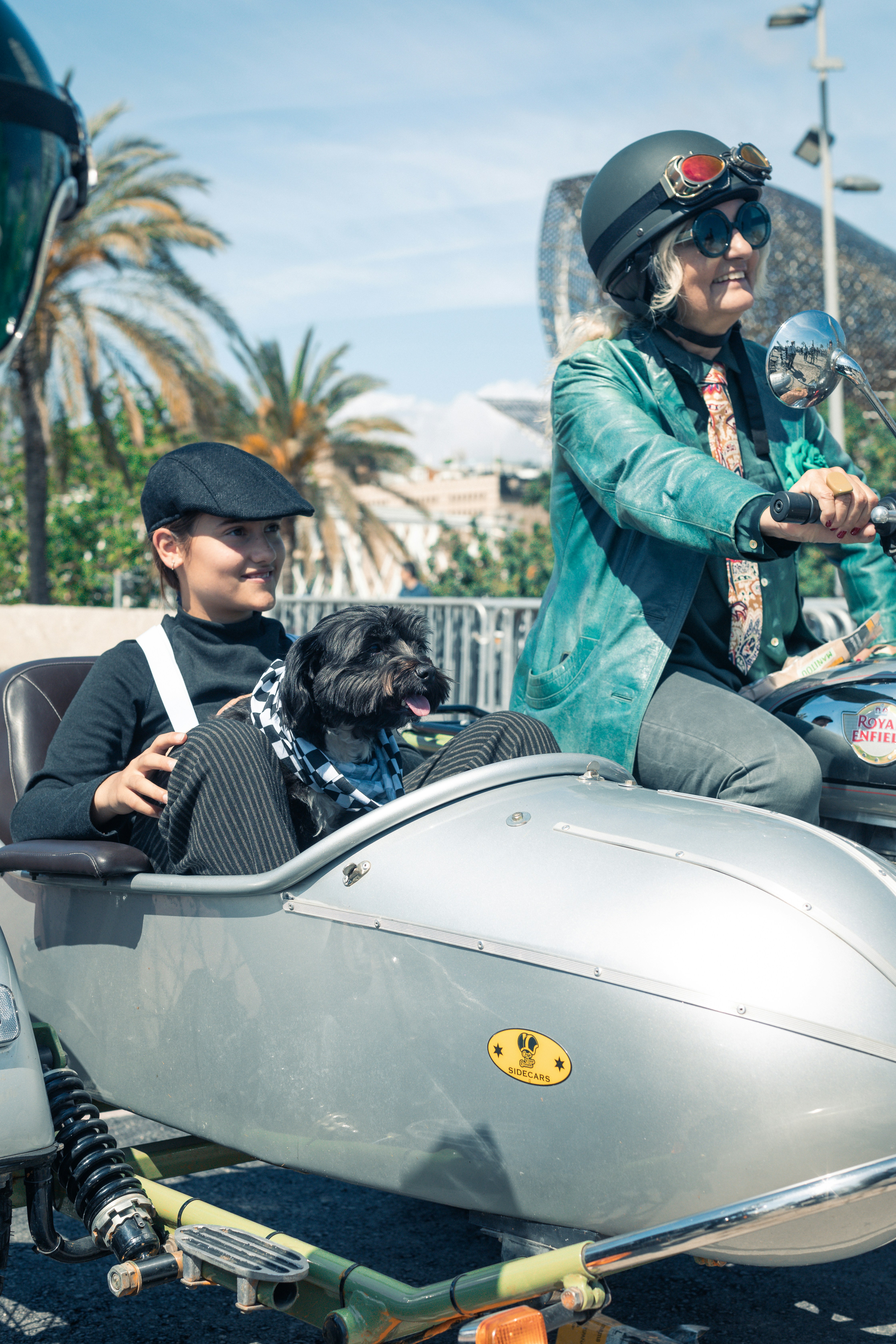 A couple of people on a motorcycle with a dog