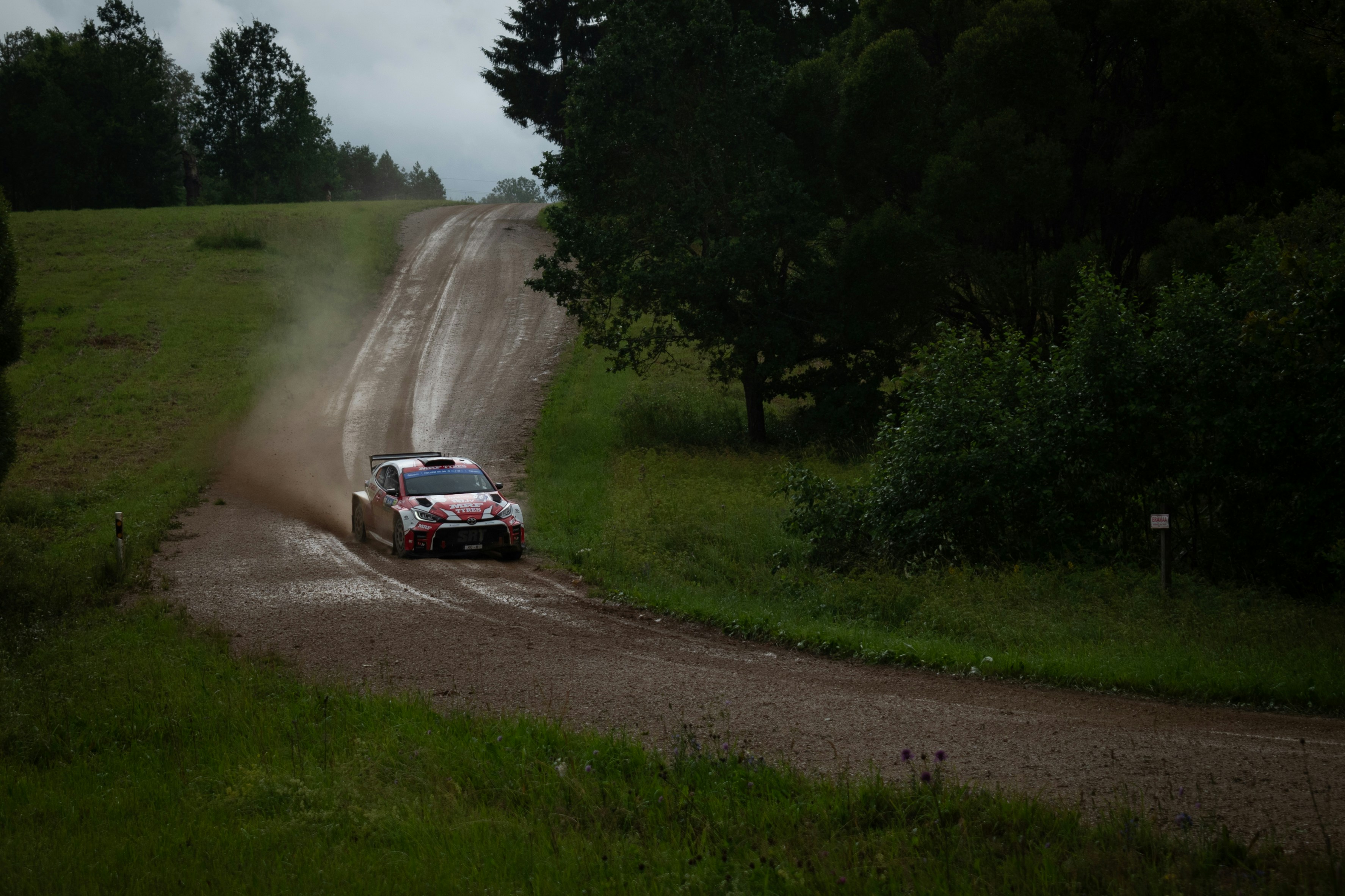 A car is driving down a dirt road