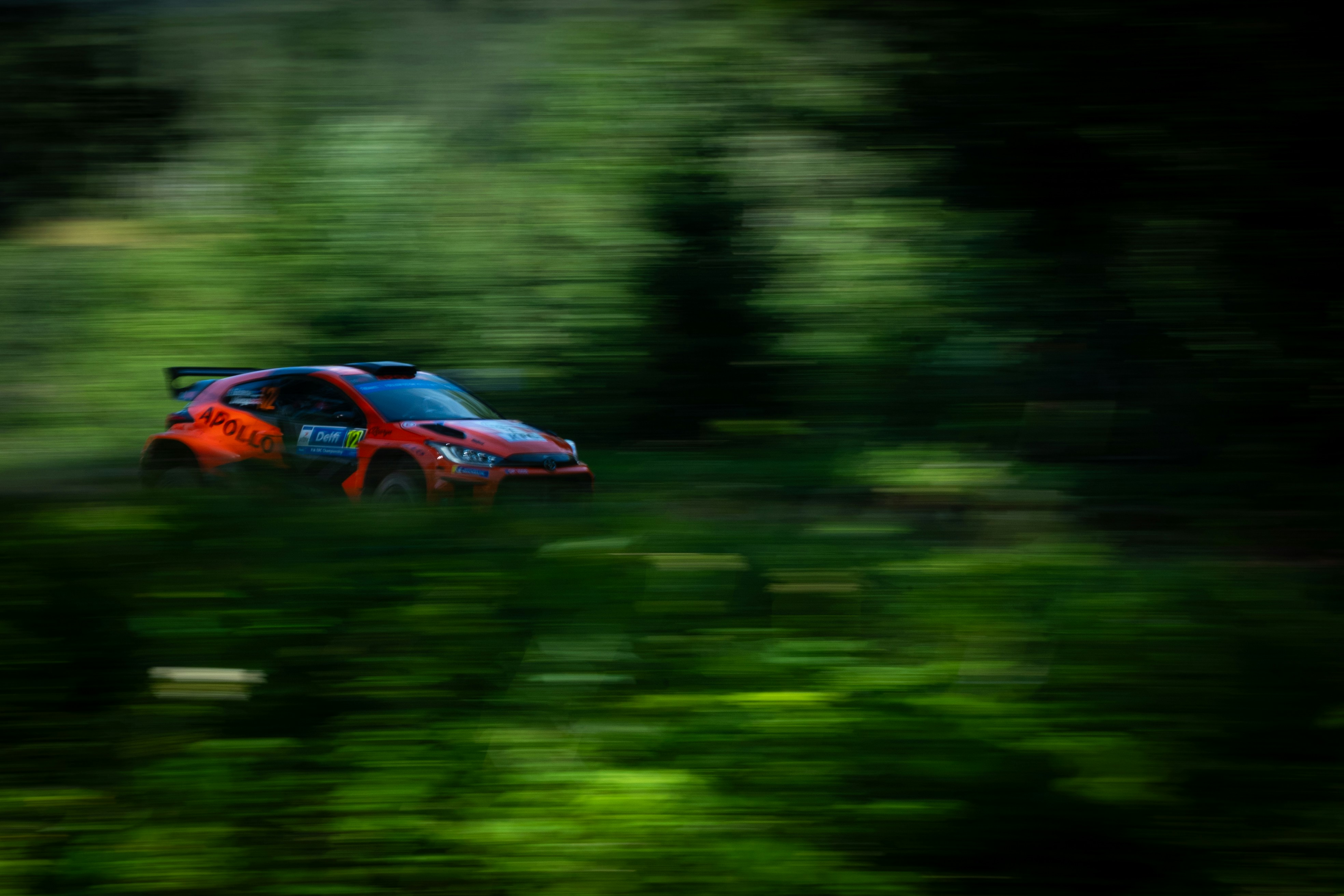 A blurry photo of a car driving through a forest