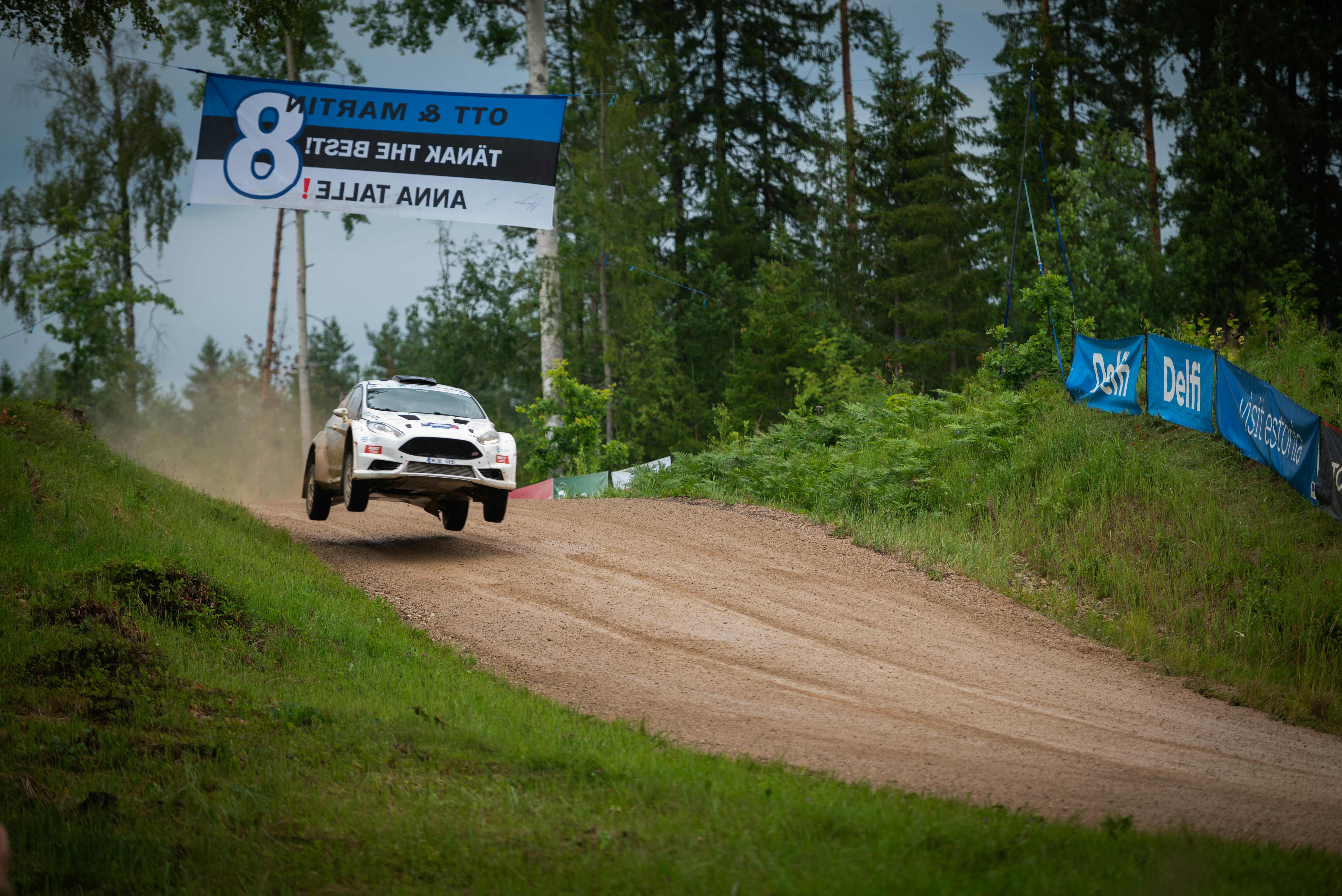 A white truck driving down a dirt road