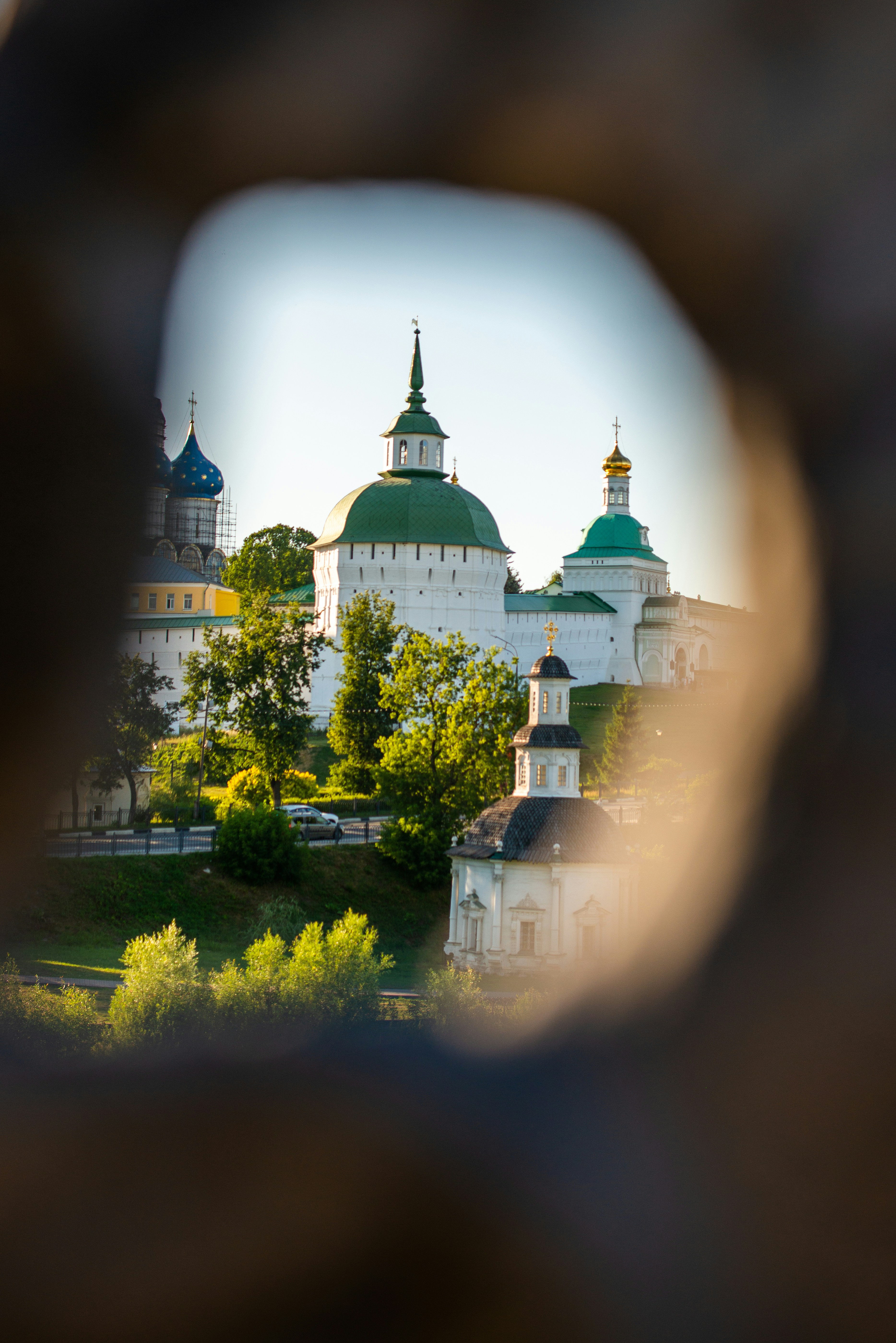 A view of a building through a hole in a stone wall