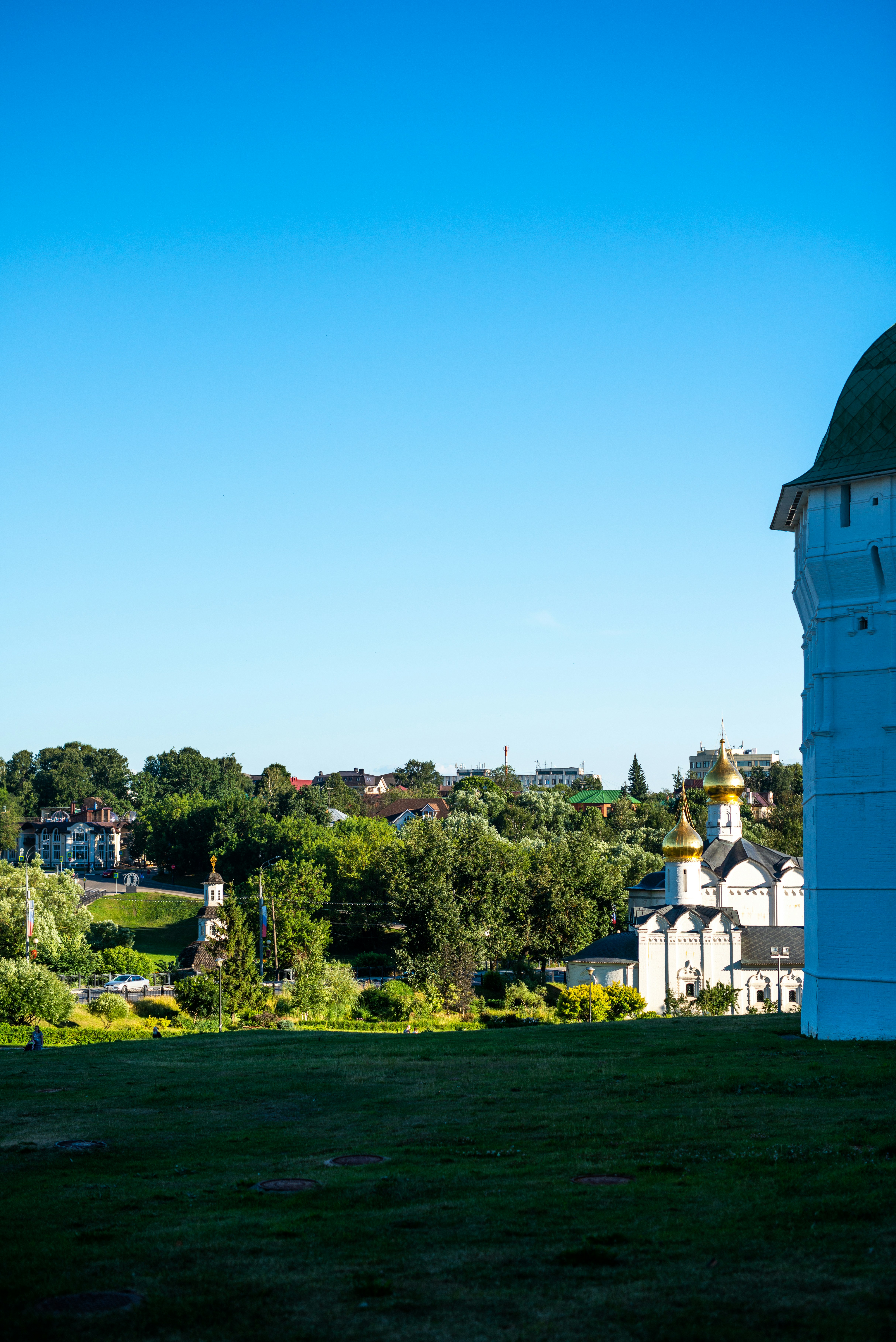 A tall white tower sitting on top of a lush green field