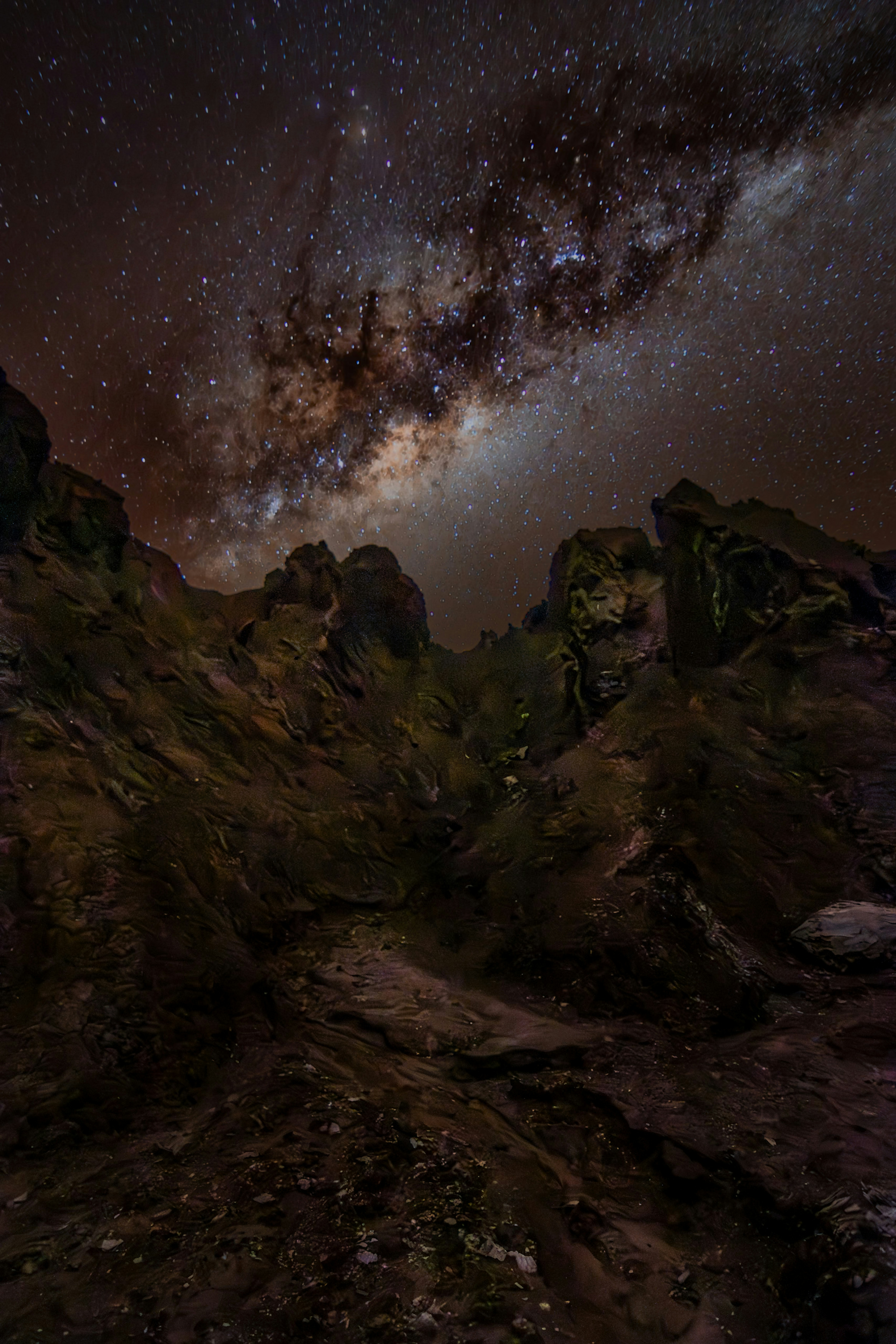 Dense star field of the Milky Way core over rocky Namibian desert terrain in total darkness