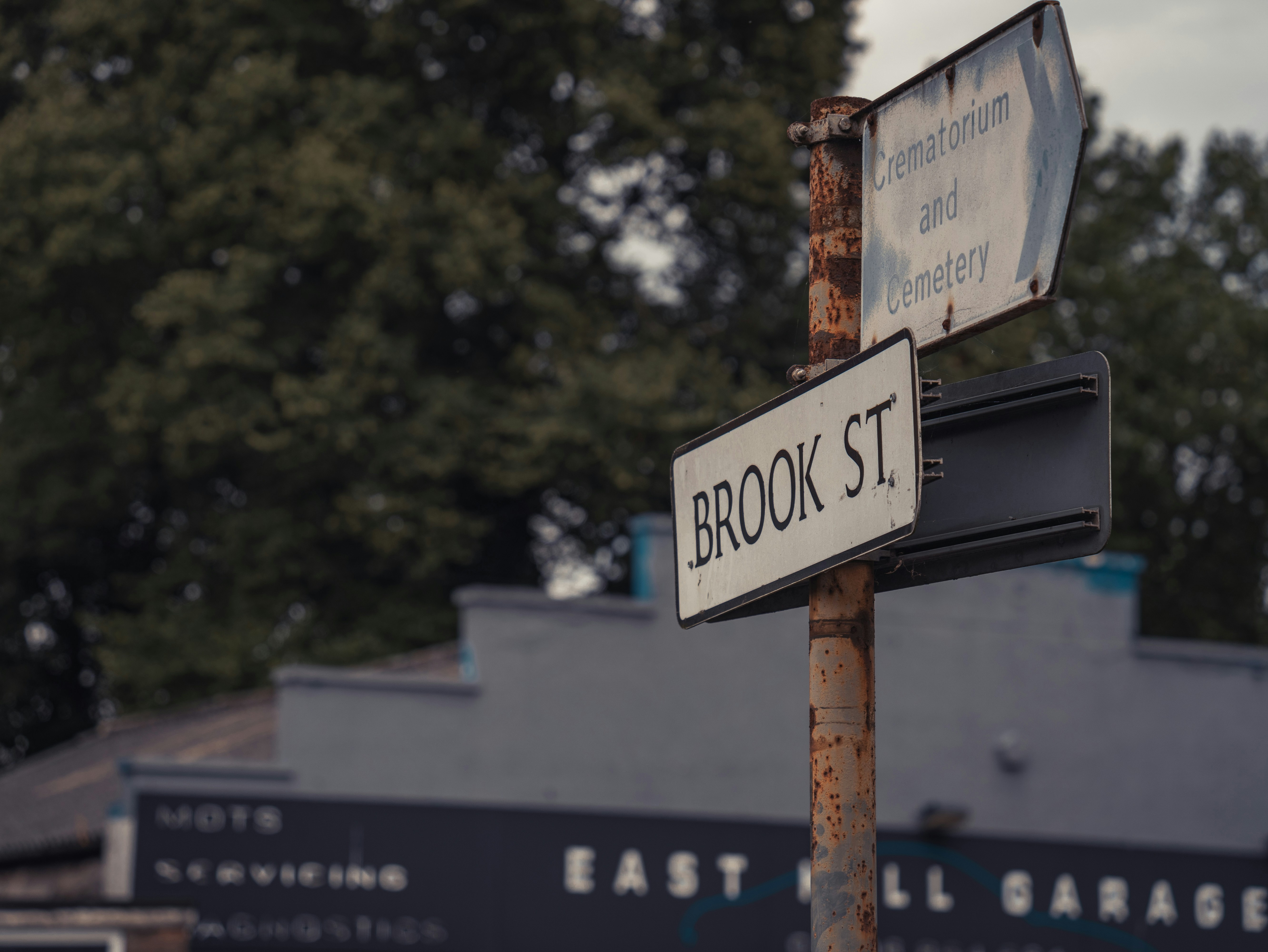 Two street signs on a pole in front of a building