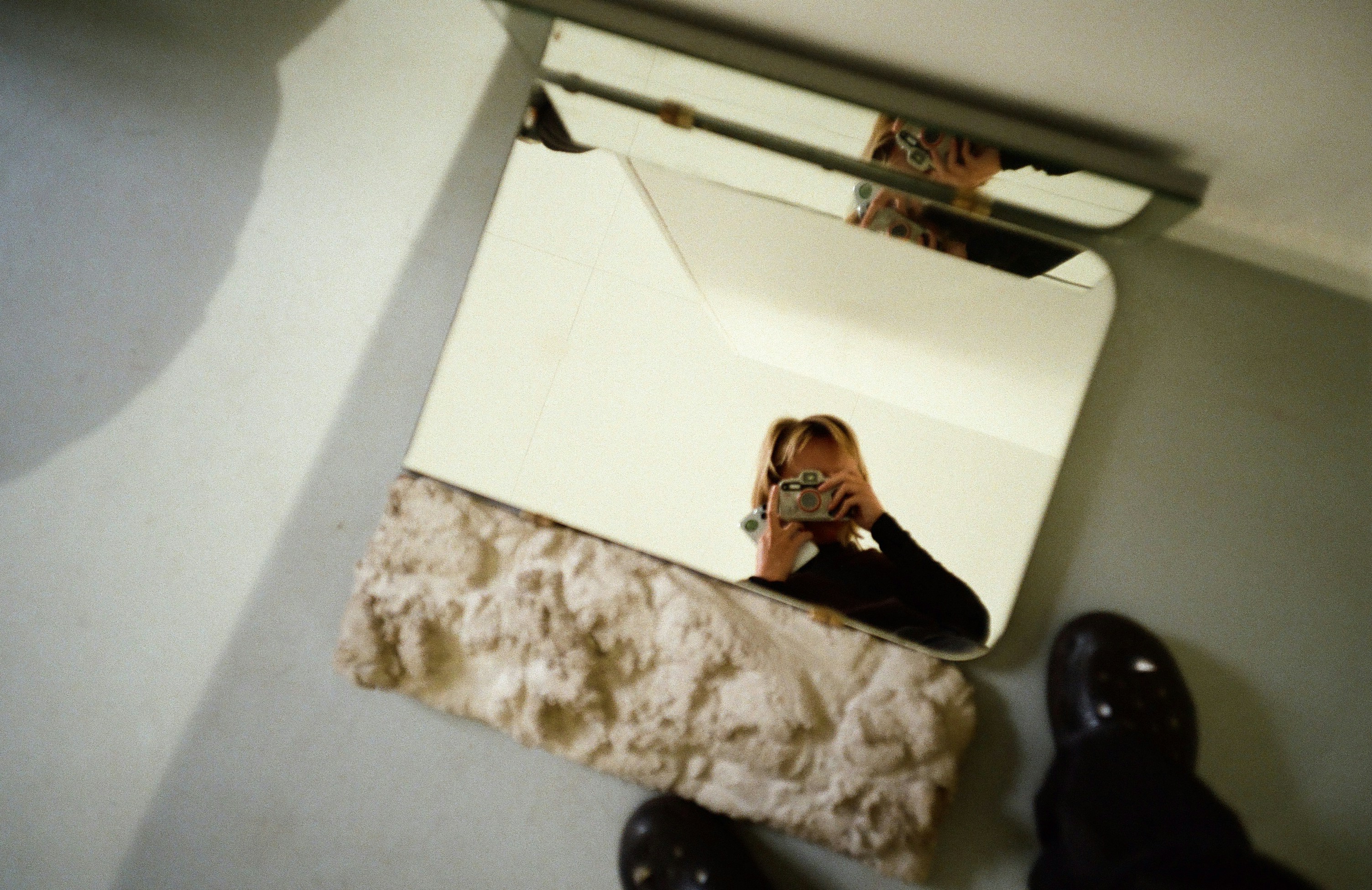 A woman is taking a picture of herself in a mirror