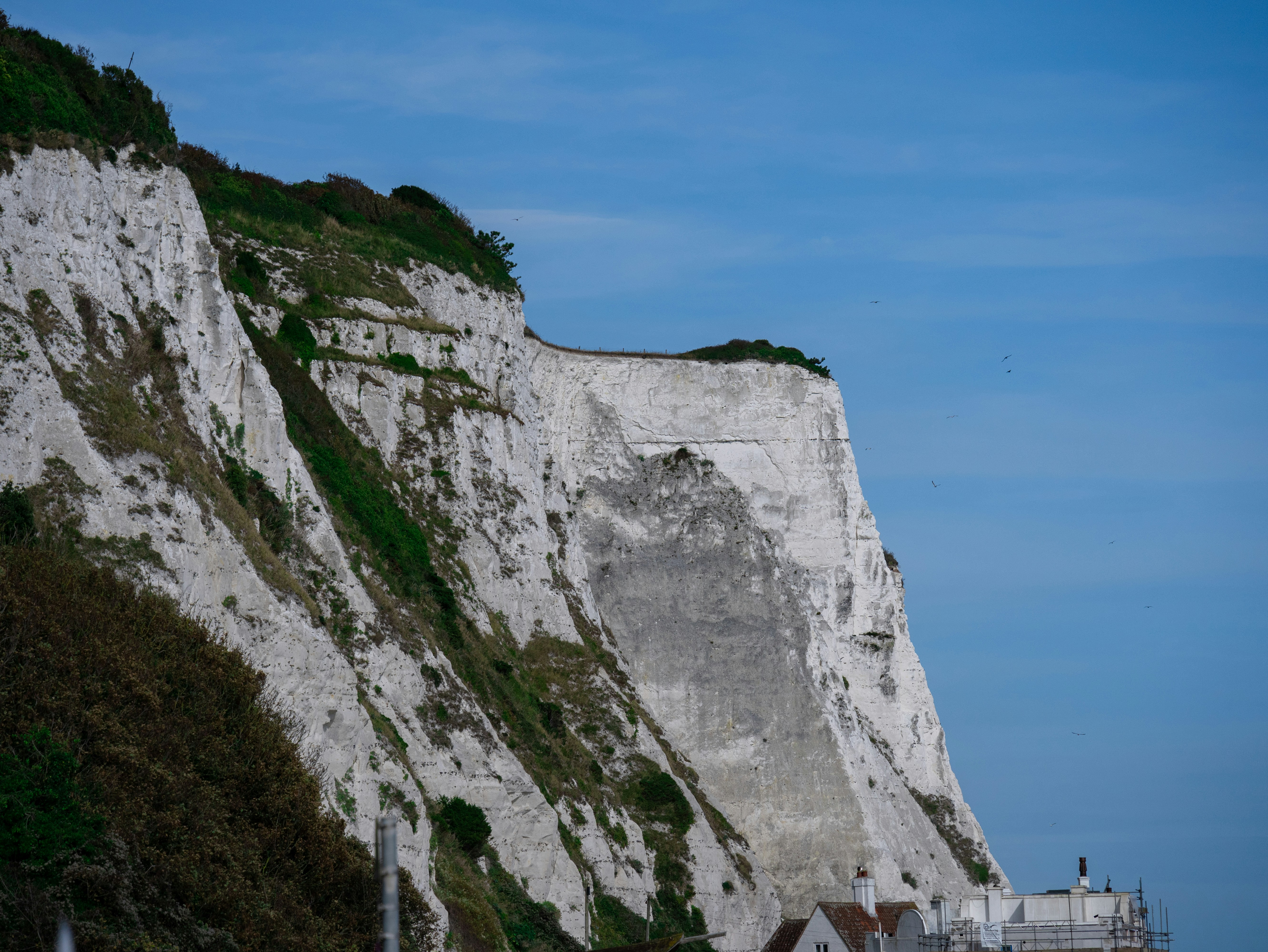 A large white cliff on the side of a beach