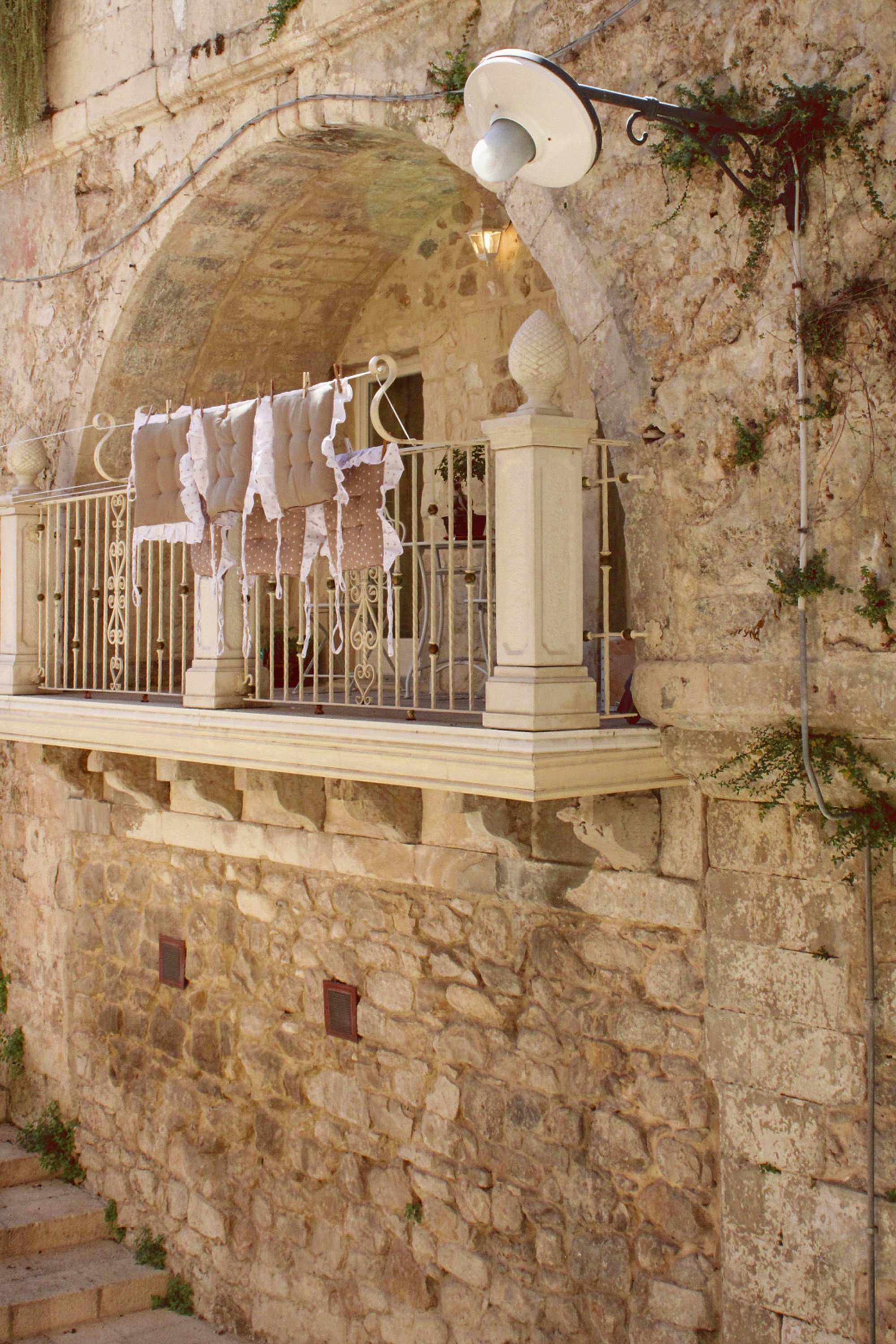 A stone building with clothes hanging on the balcony