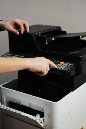 A person is pressing a button on a printer