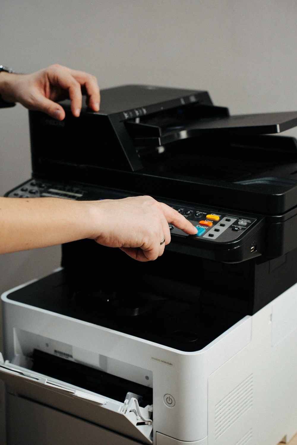 Person pressing buttons on an office printer control panel