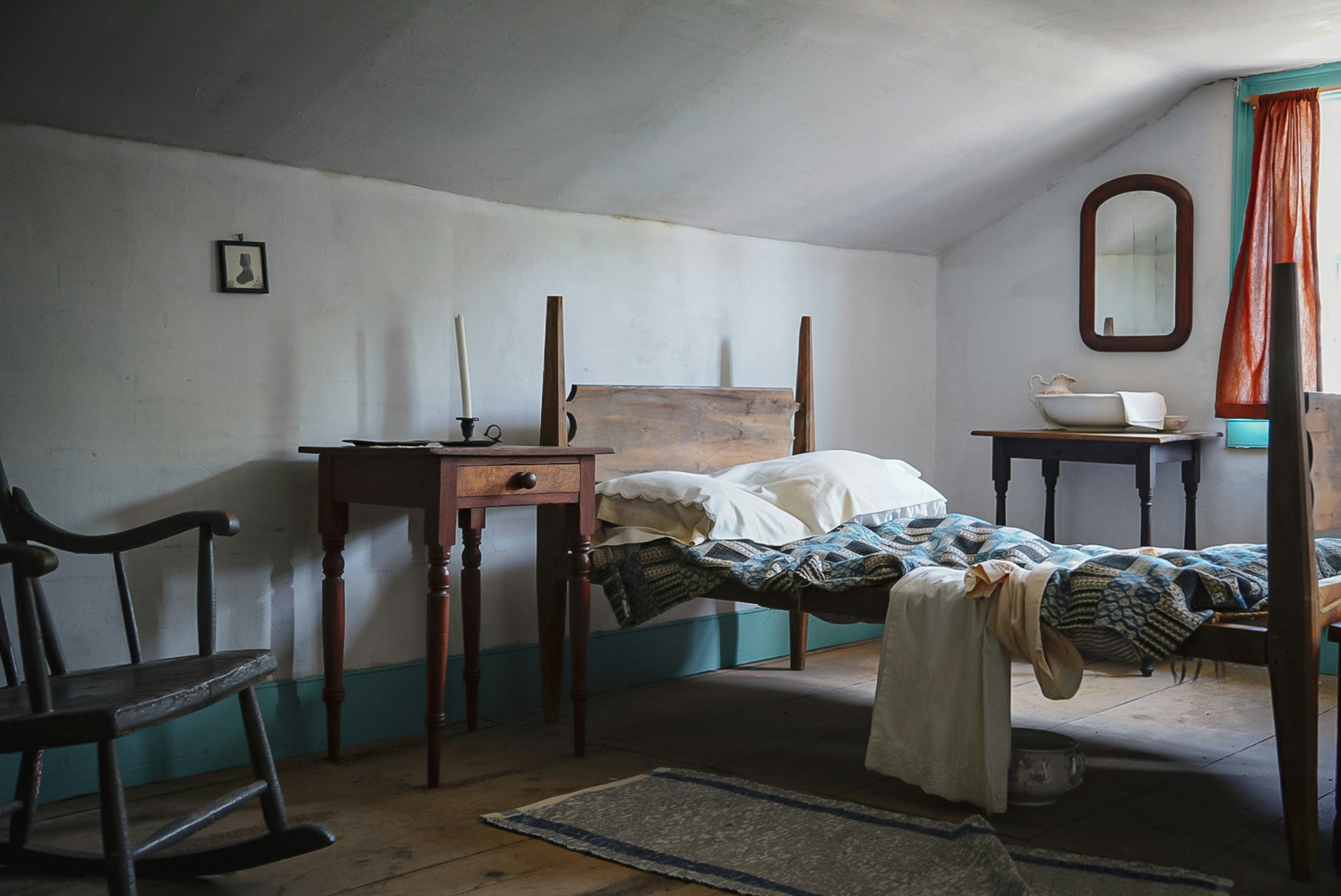 Un dormitorio con cama, cómoda, silla y espejo
