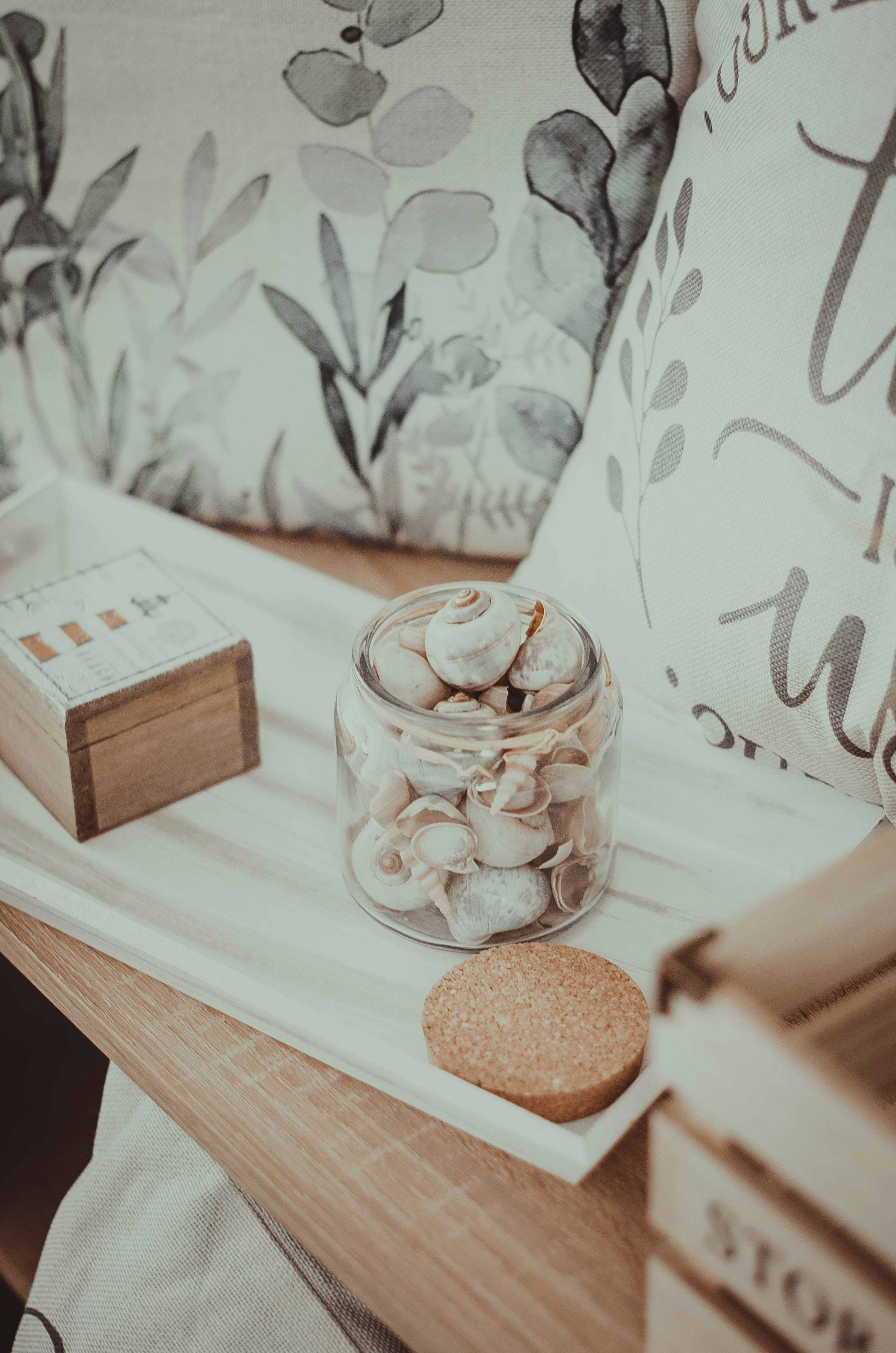 A wooden table topped with a glass jar filled with coins