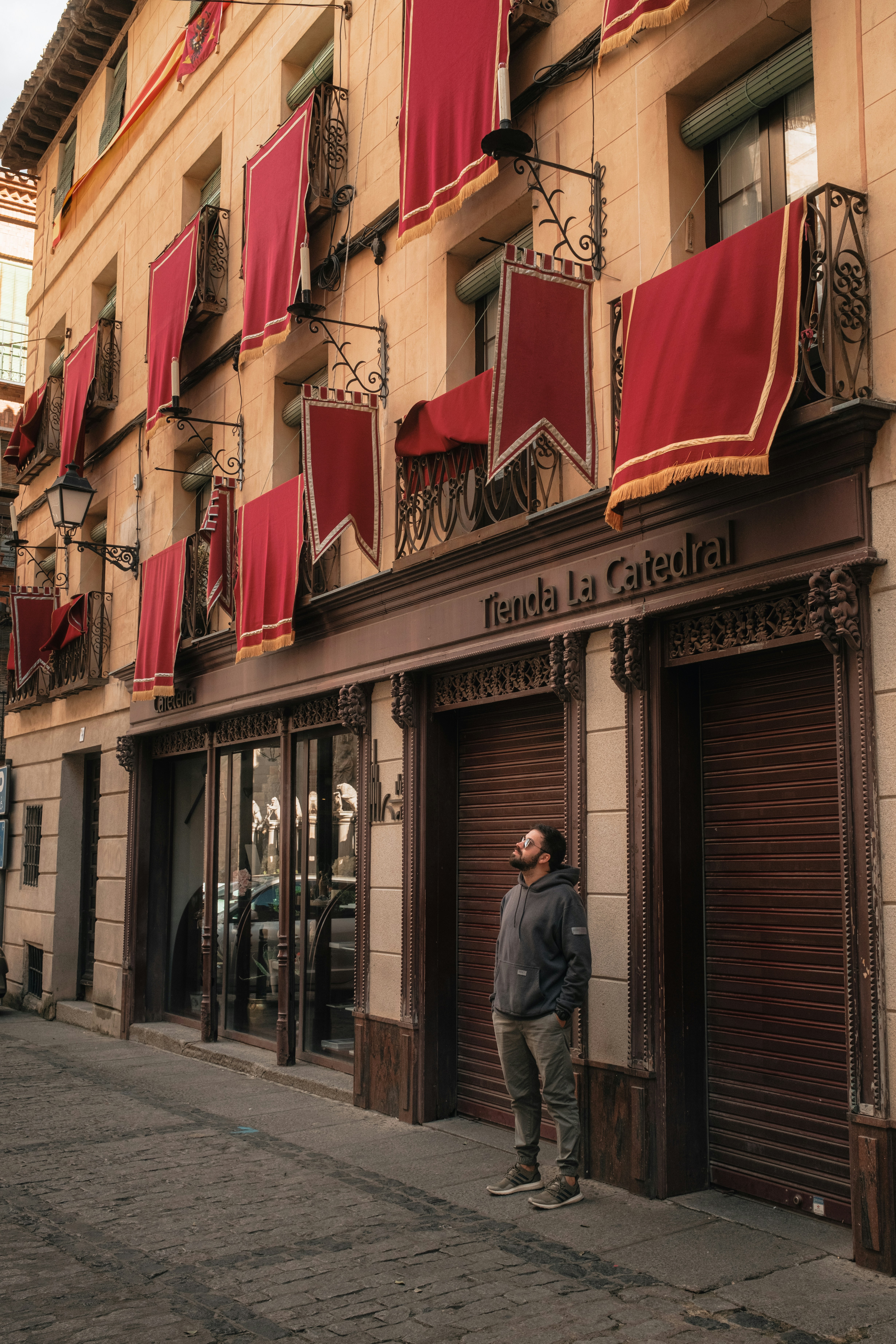 A man standing in front of a building with red curtains