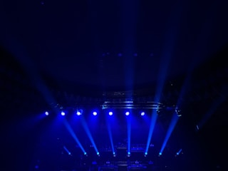 A group of people on a stage with blue lights