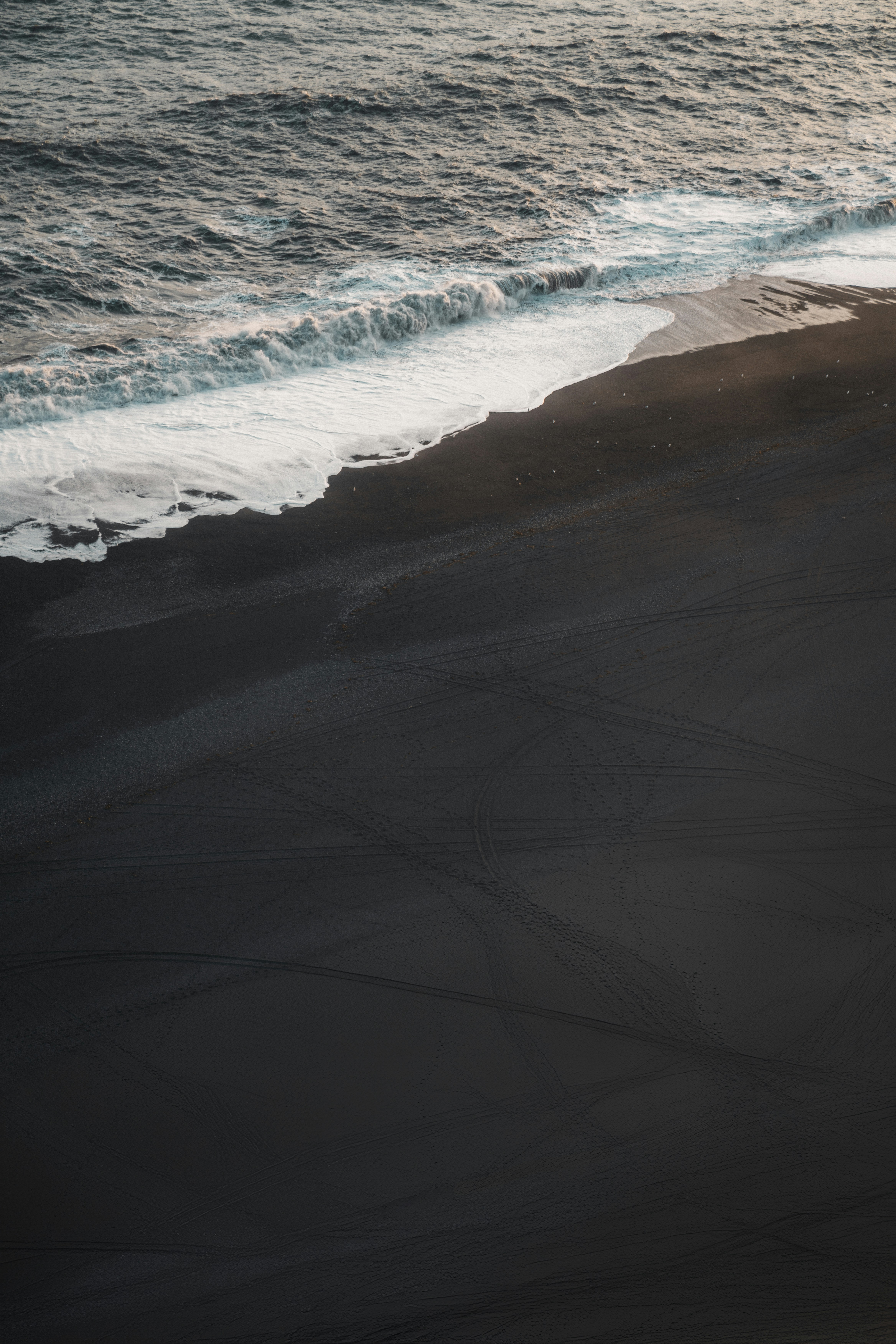 A man riding a surfboard on top of a sandy beach