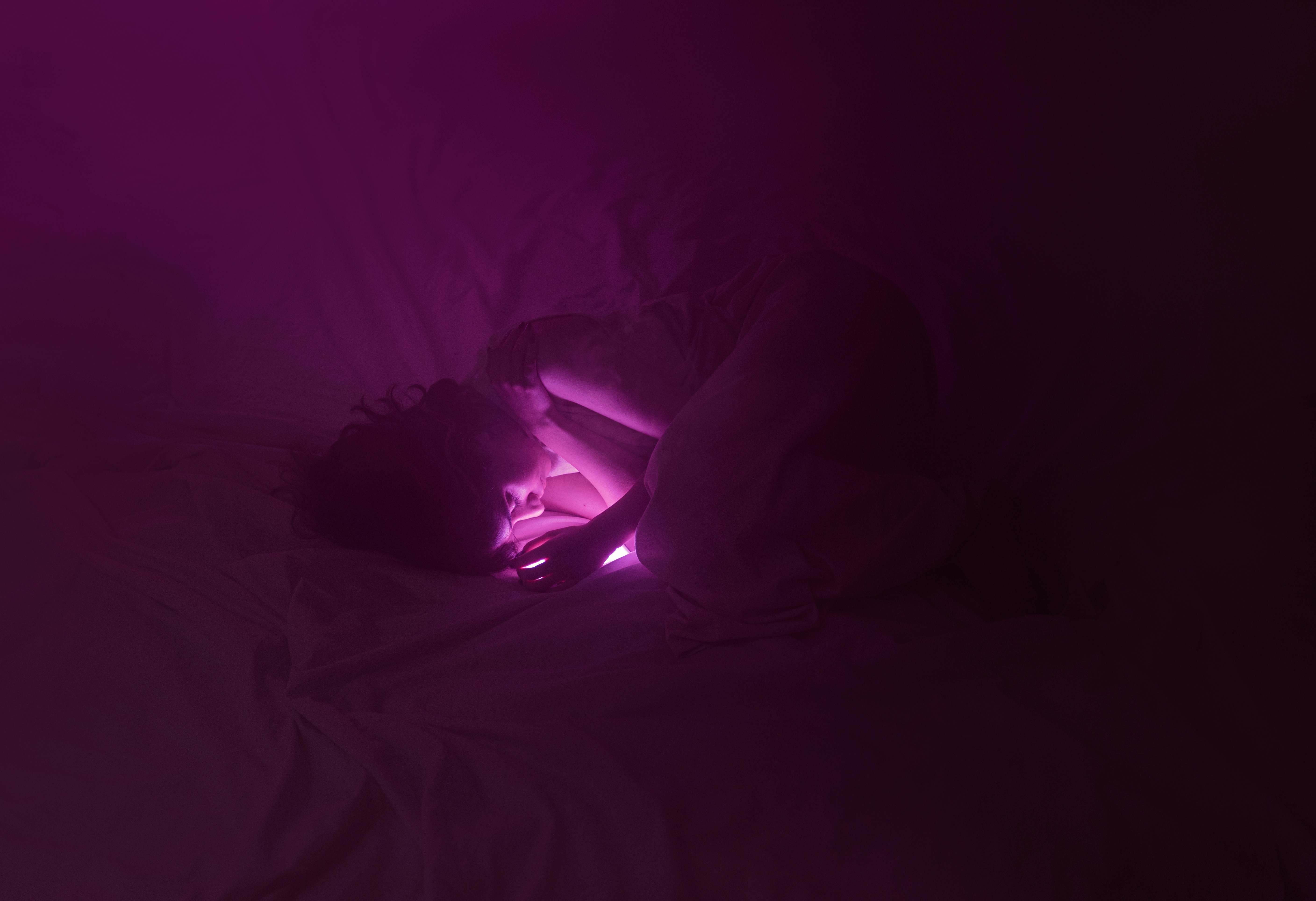 A bed with a purple light in the middle of it