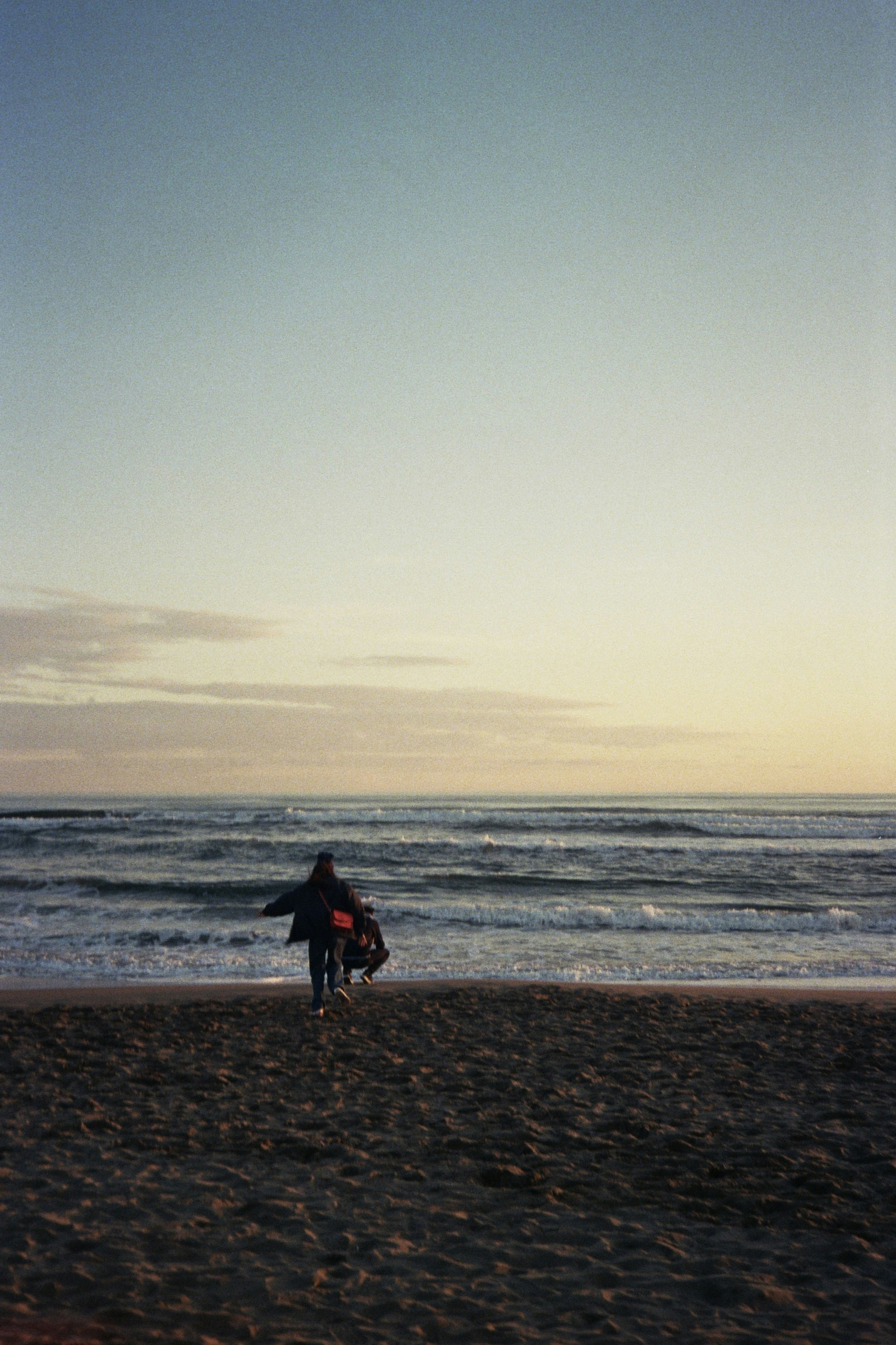 A person walking on a beach with a surfboard