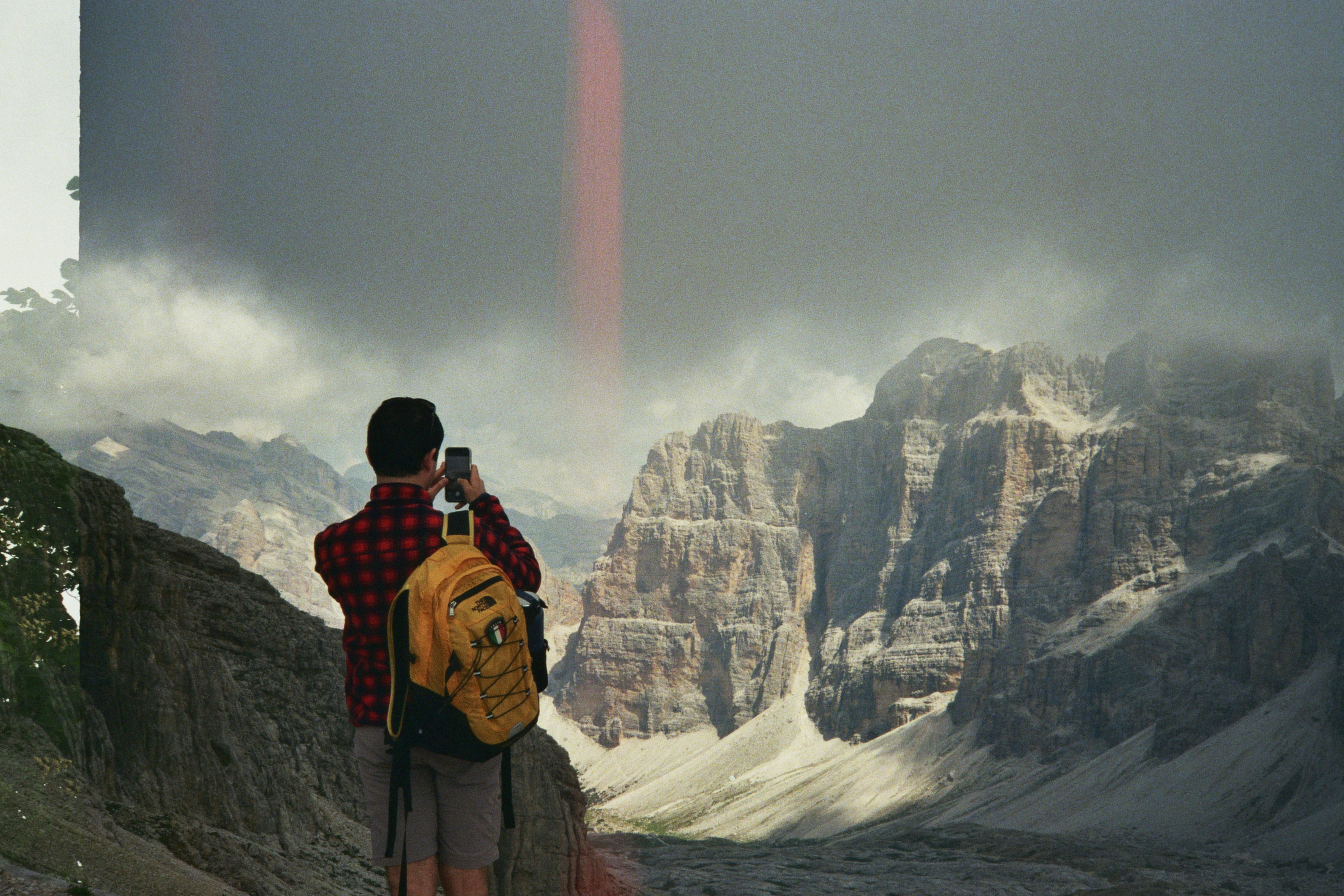 A man taking a picture of a mountain range