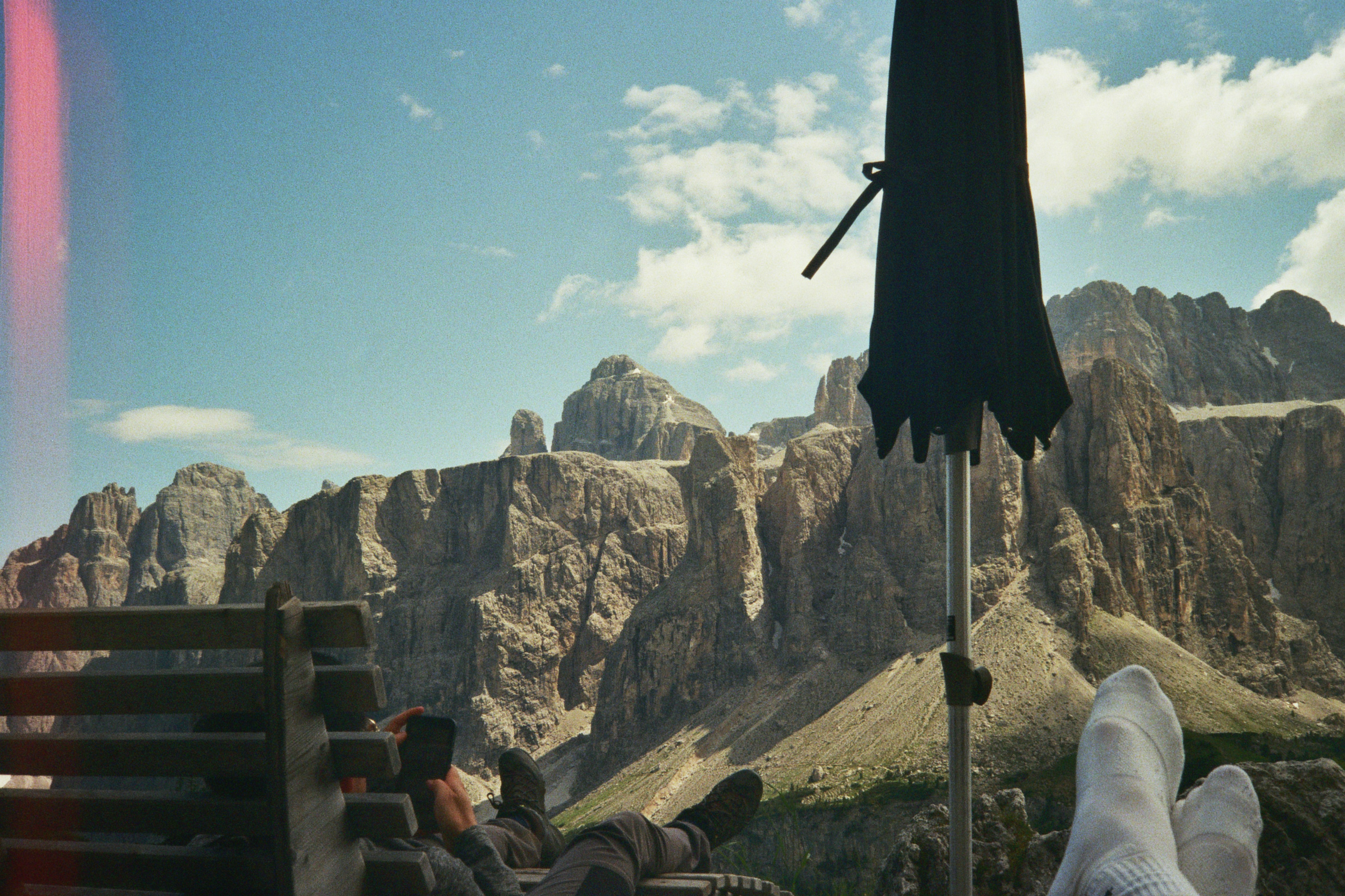 A person sitting on a bench with an umbrella over their head