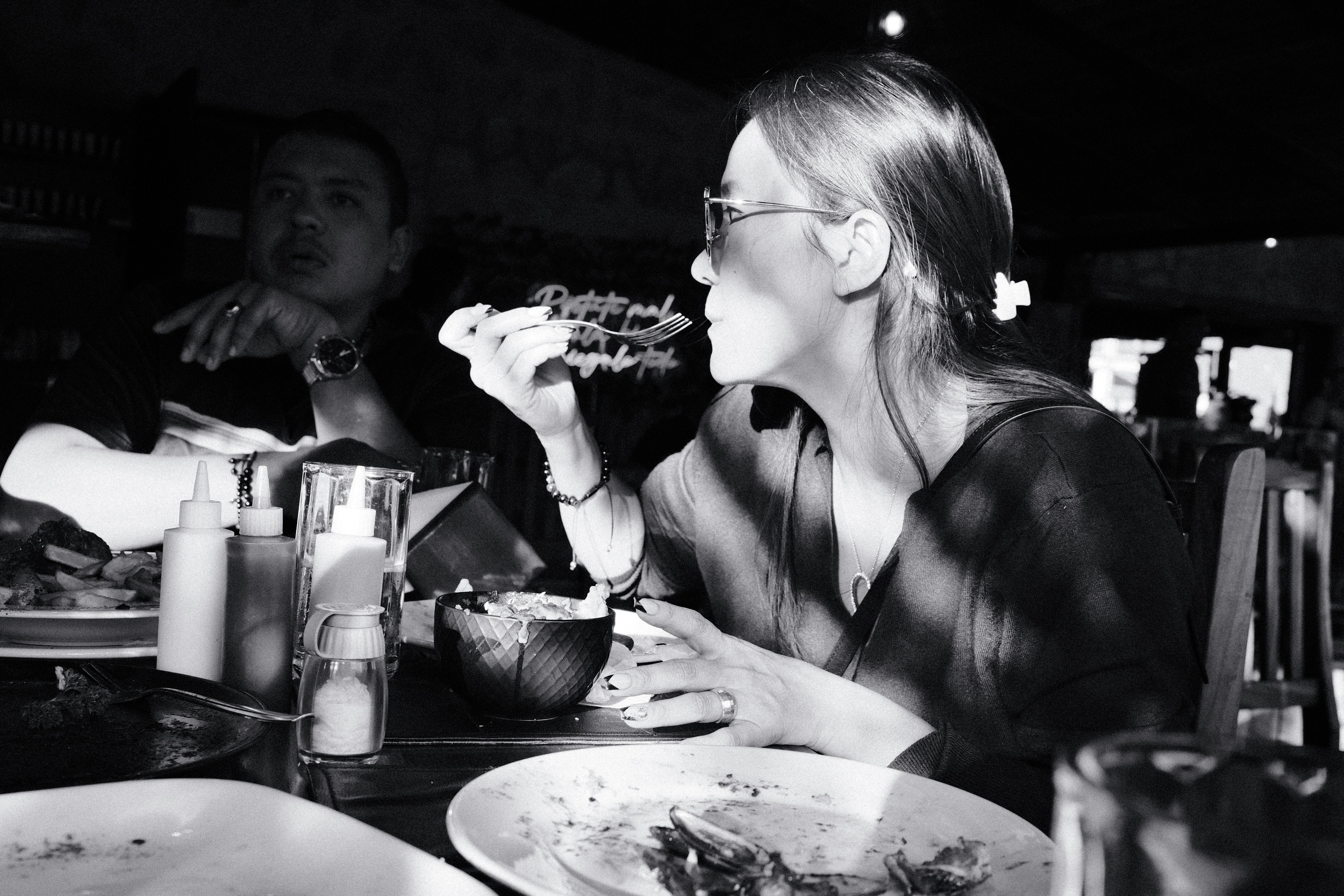 A woman sitting at a table eating a piece of pizza, Having lunch at a german heritage restaurant