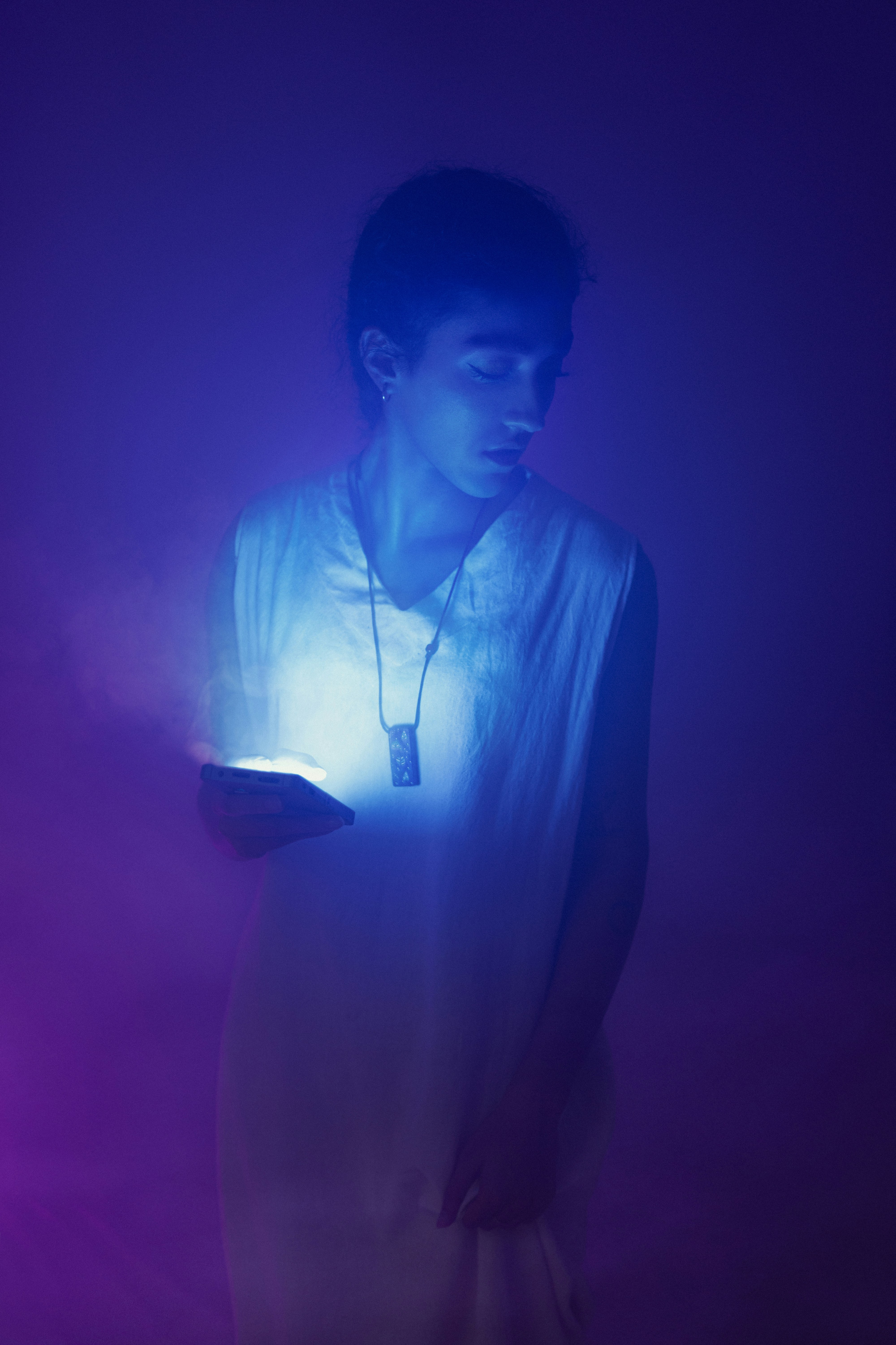 A man standing in the dark holding a lit object