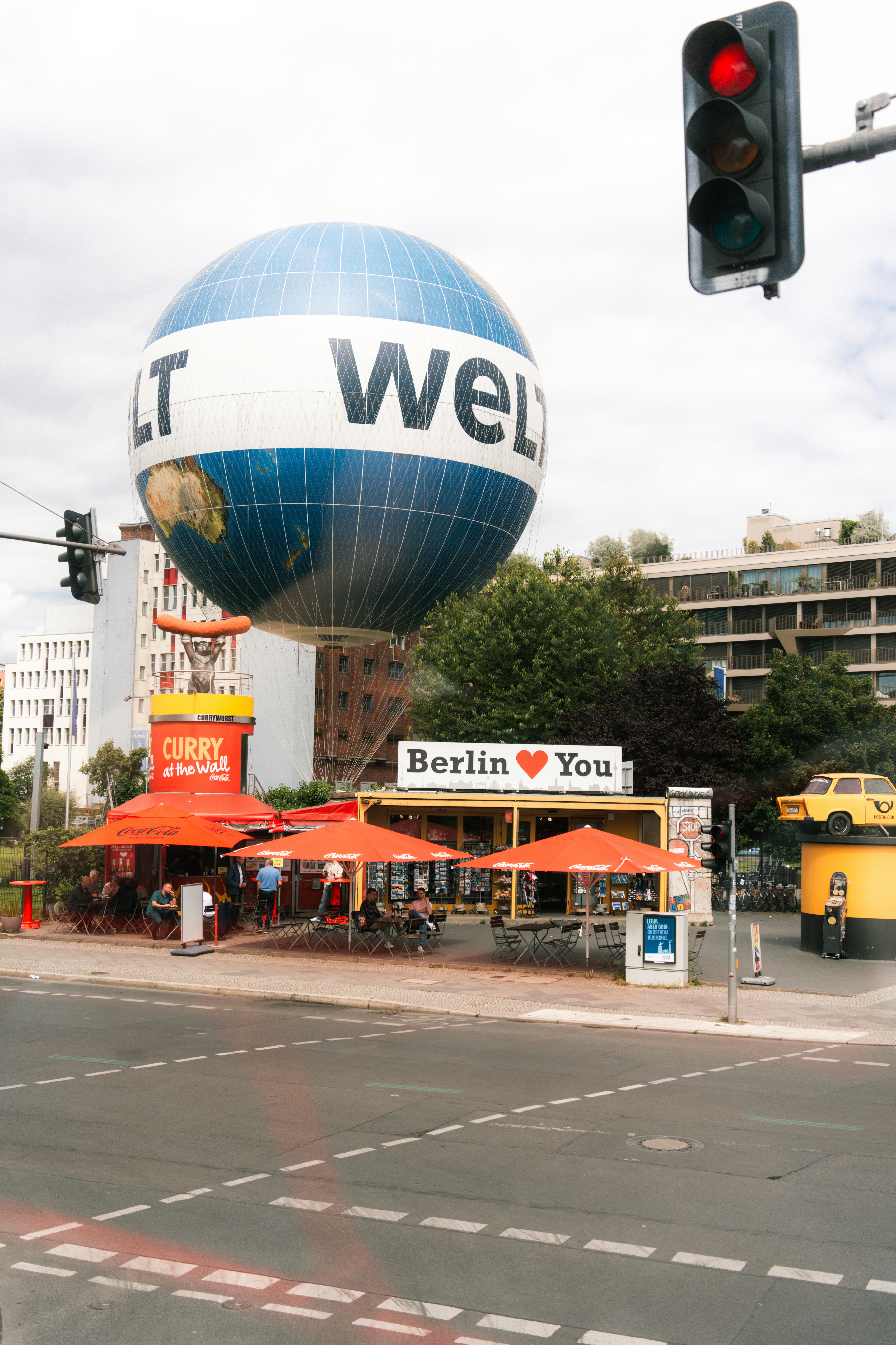 A street corner with a traffic light and a hot air balloon