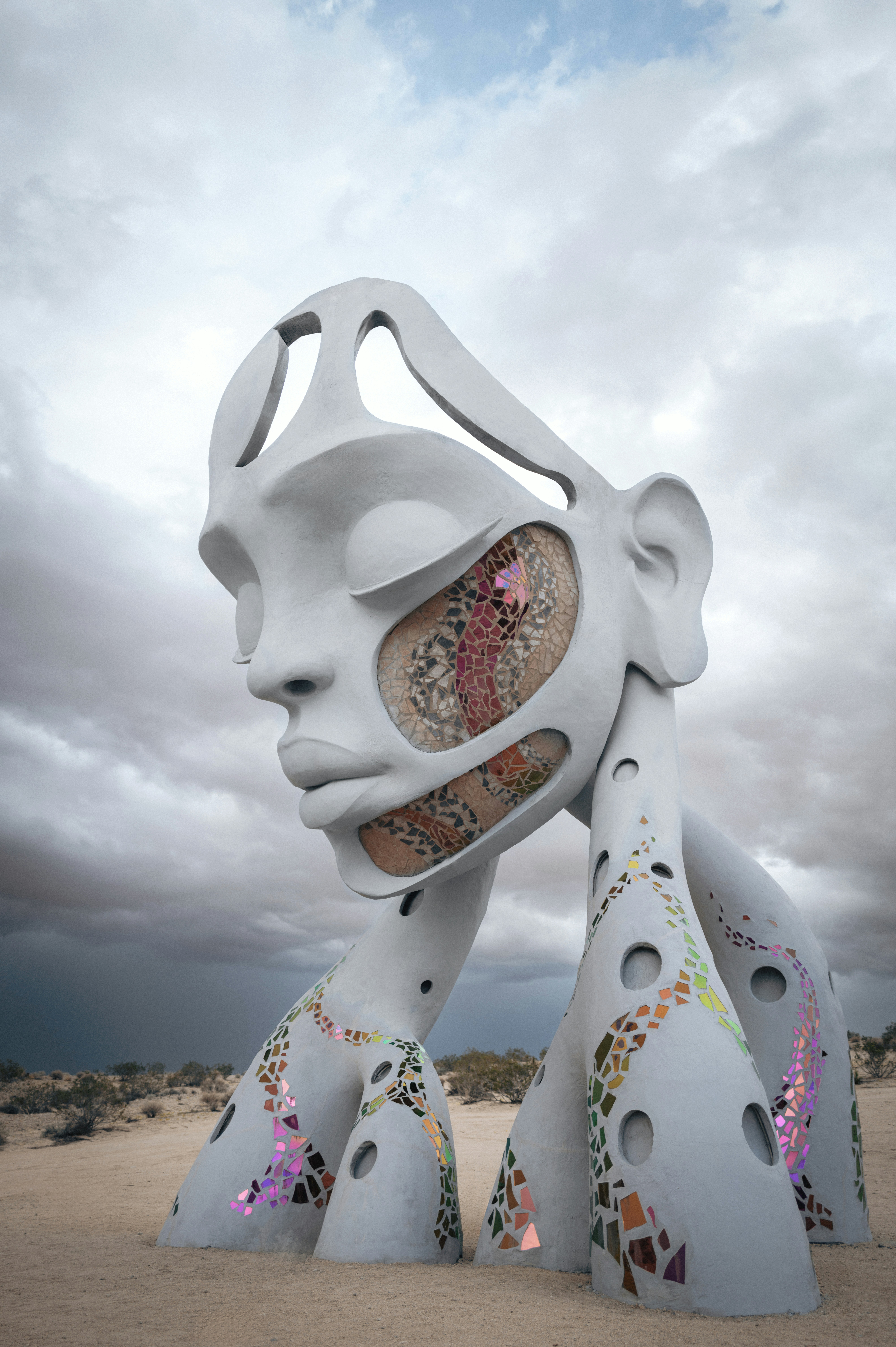 A sculpture of a woman's face with a sky background