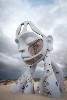 A sculpture of a woman's face with a sky background