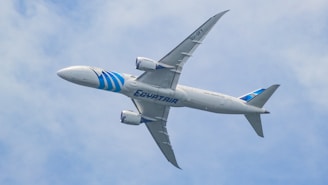 A large jetliner flying through a blue cloudy sky