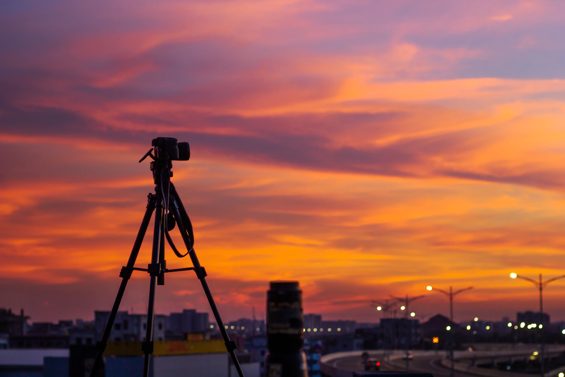 A camera on a tripod in front of a sunset