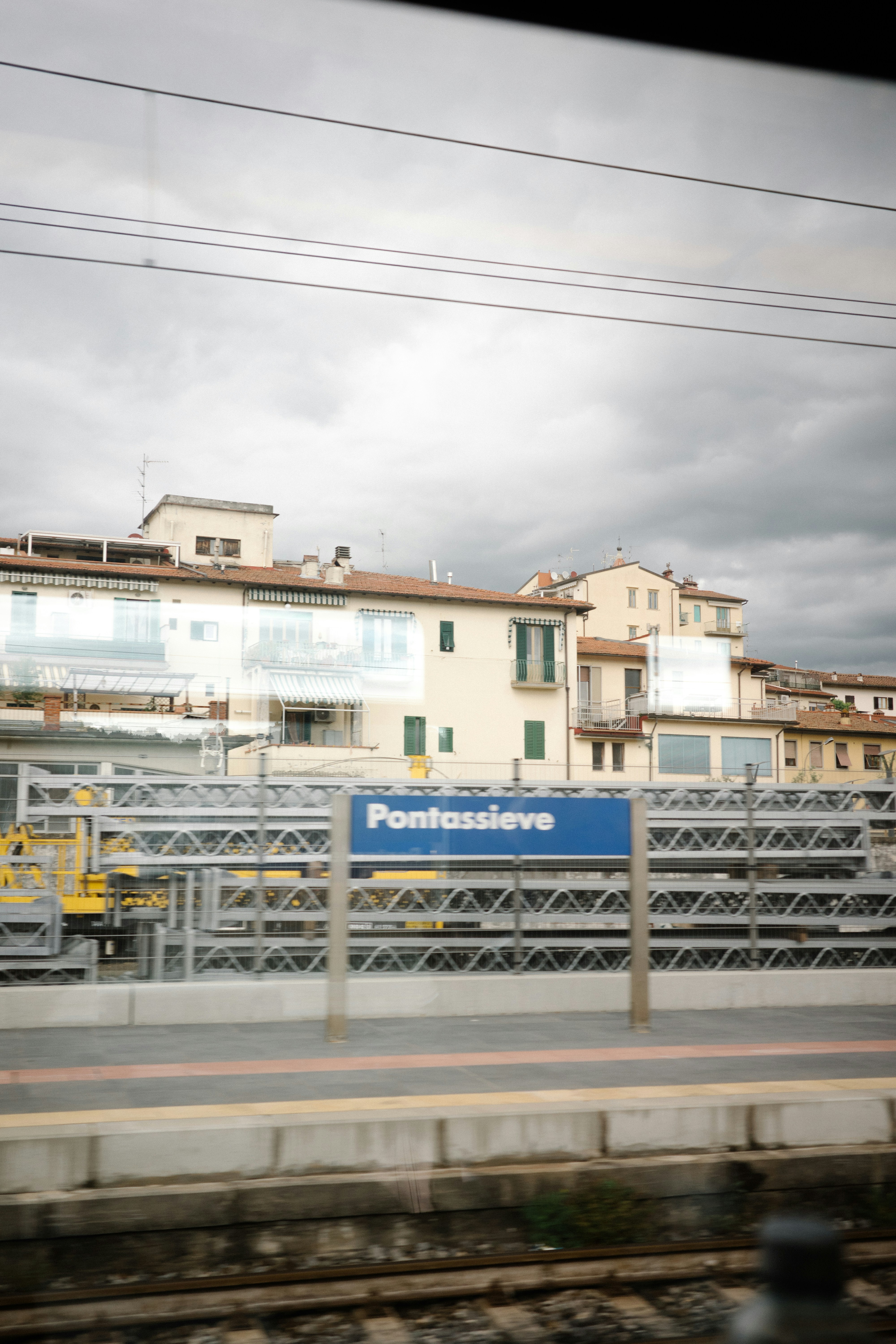 A train traveling past a train station next to a tall building