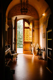 A hallway with a large wooden door leading to another room