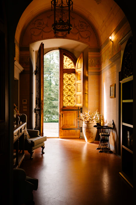 A hallway with a large wooden door leading to another room