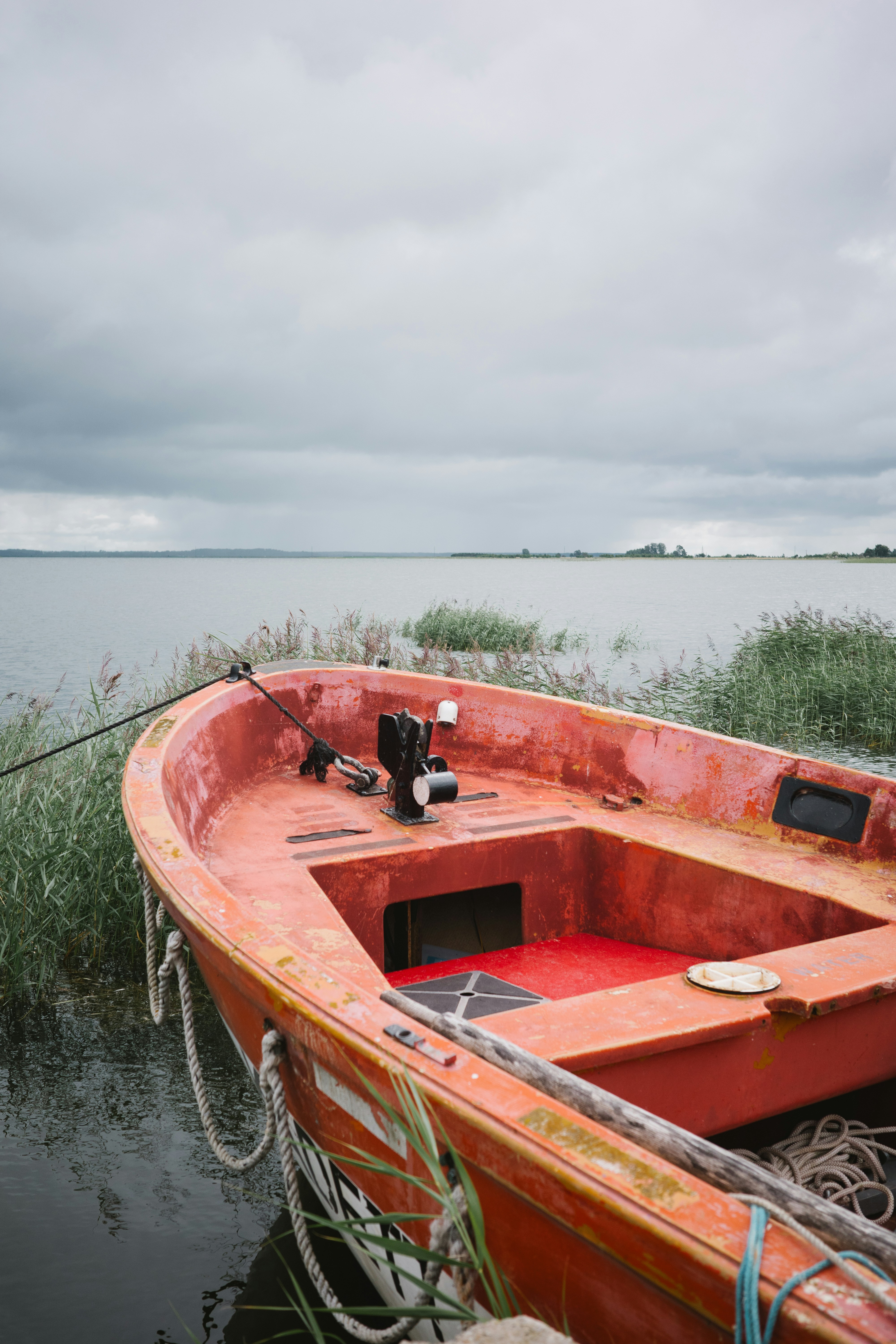 Una barca rossa seduta in cima a uno specchio d'acqua