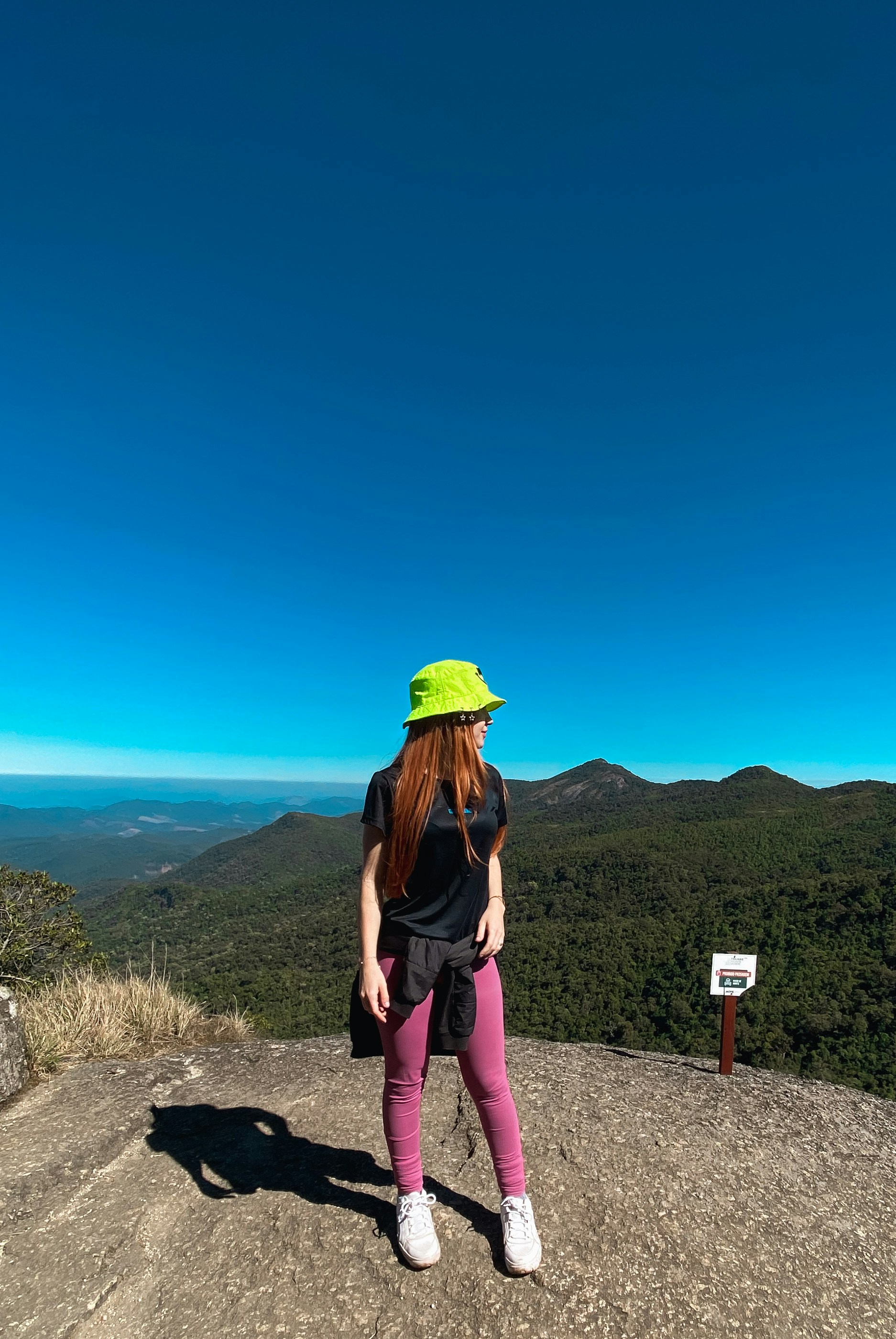 A woman standing on top of a mountain