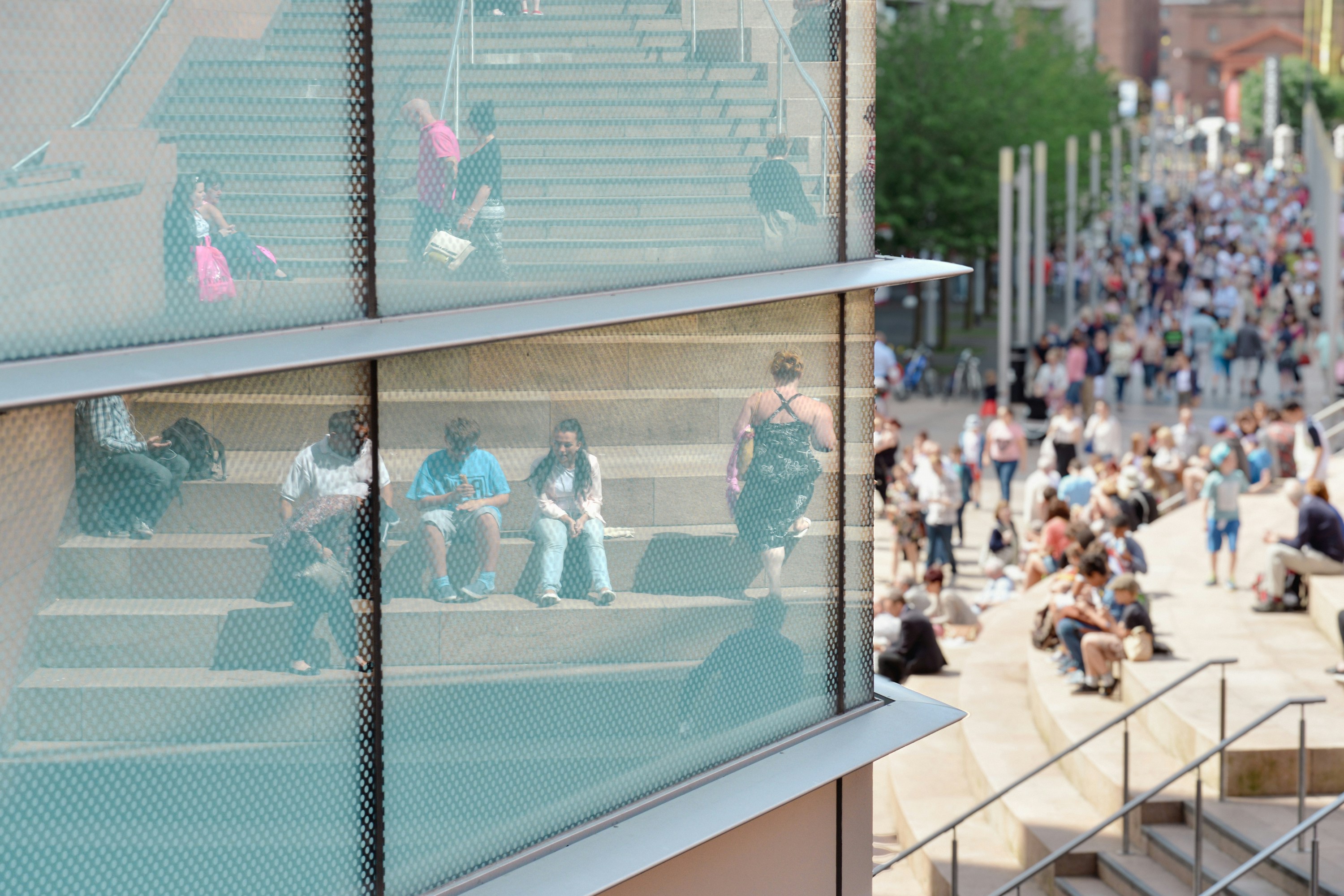A crowd of people walking down a street next to tall buildings