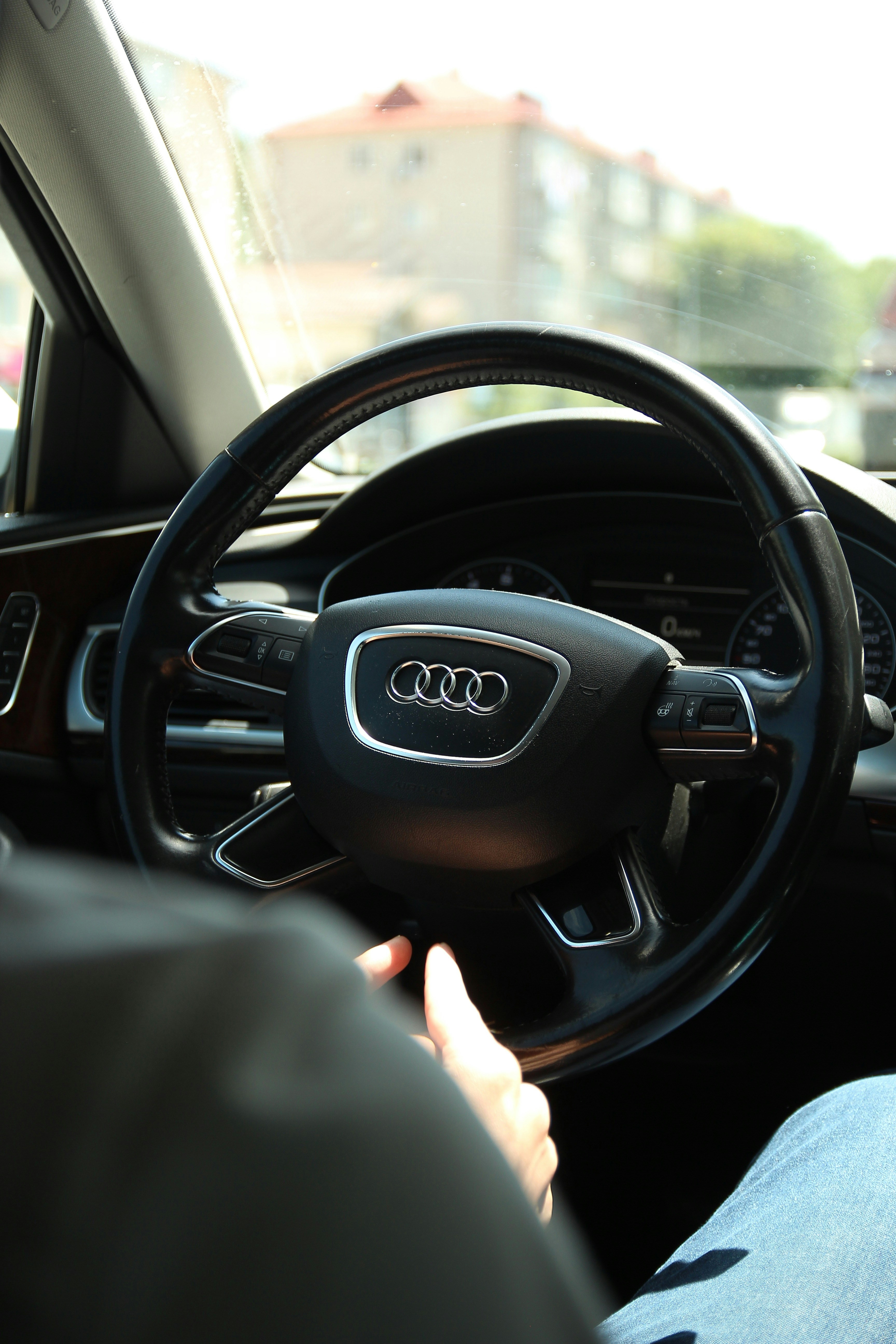 A man driving a car with a steering wheel