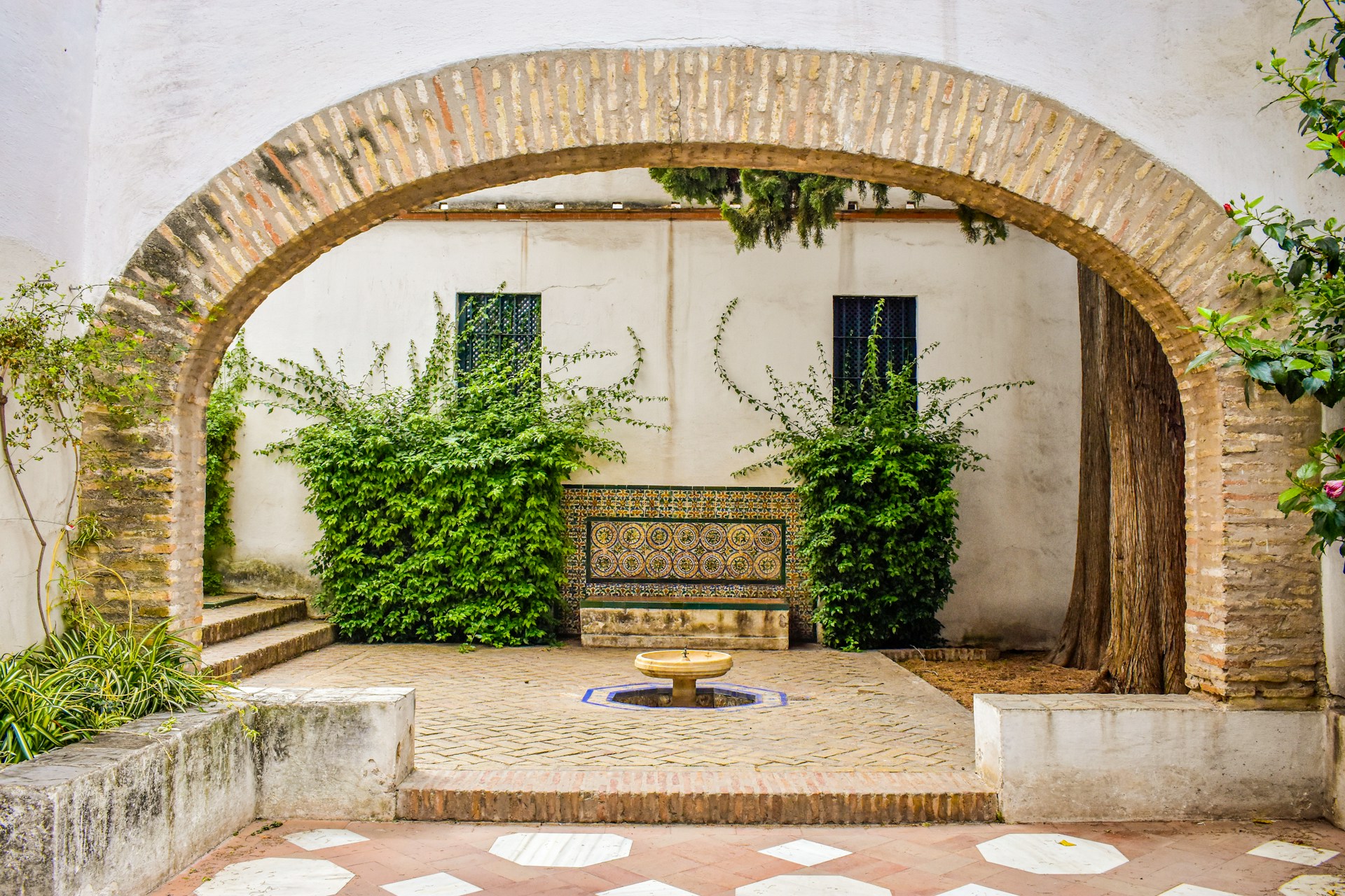A courtyard with a bench and potted plants