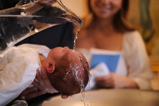 A baby being washed in a kitchen sink
