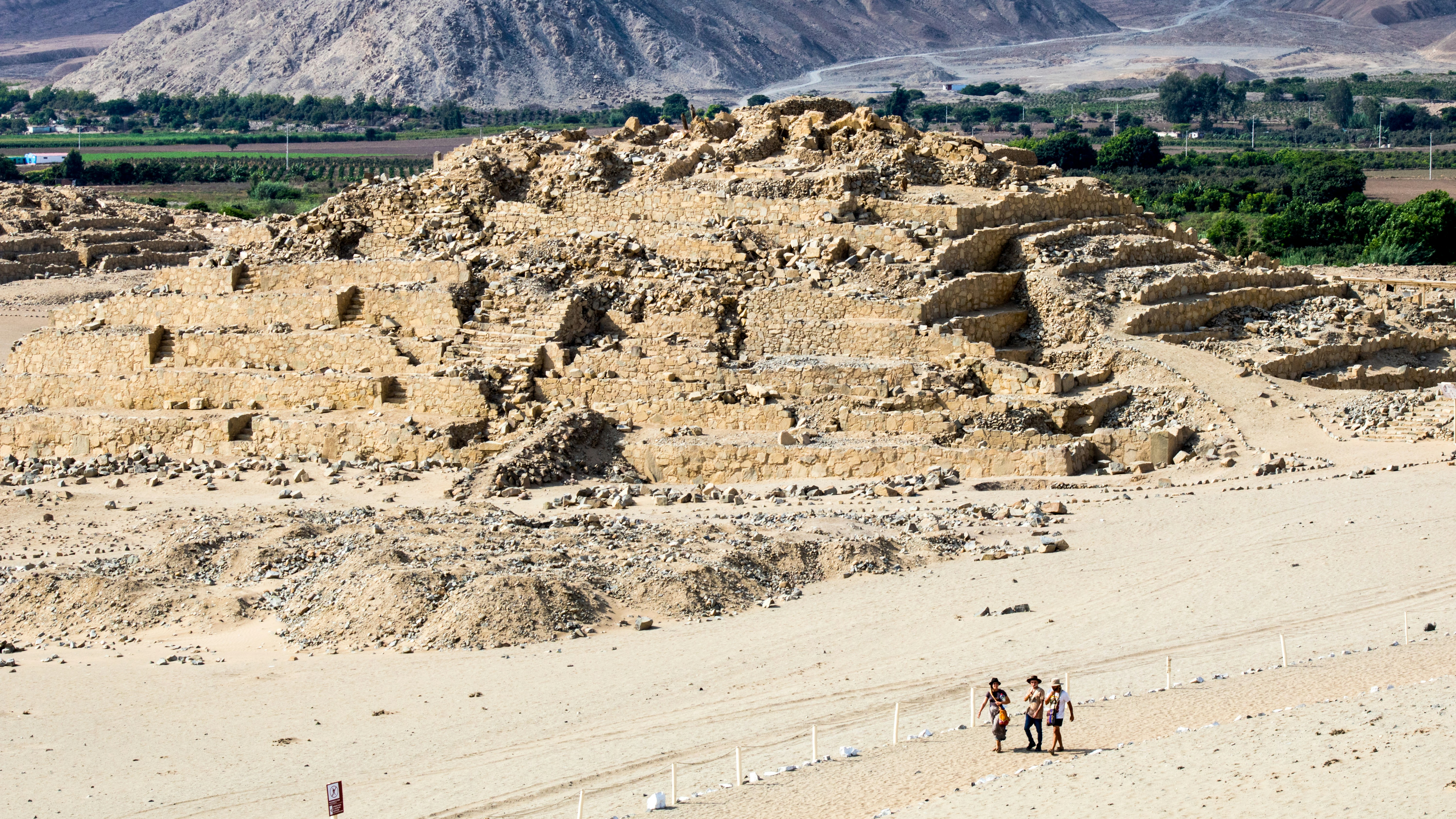 A group of people standing on top of a sandy beach