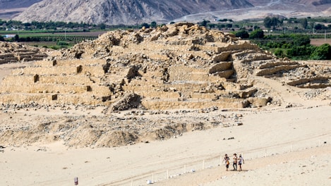A group of people standing on top of a sandy beach