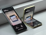Two cell phones sitting next to each other on a window sill