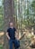 A man standing next to a tree in a forest