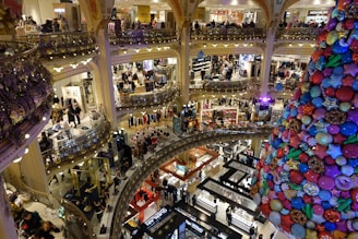 A large christmas tree in a mall filled with people