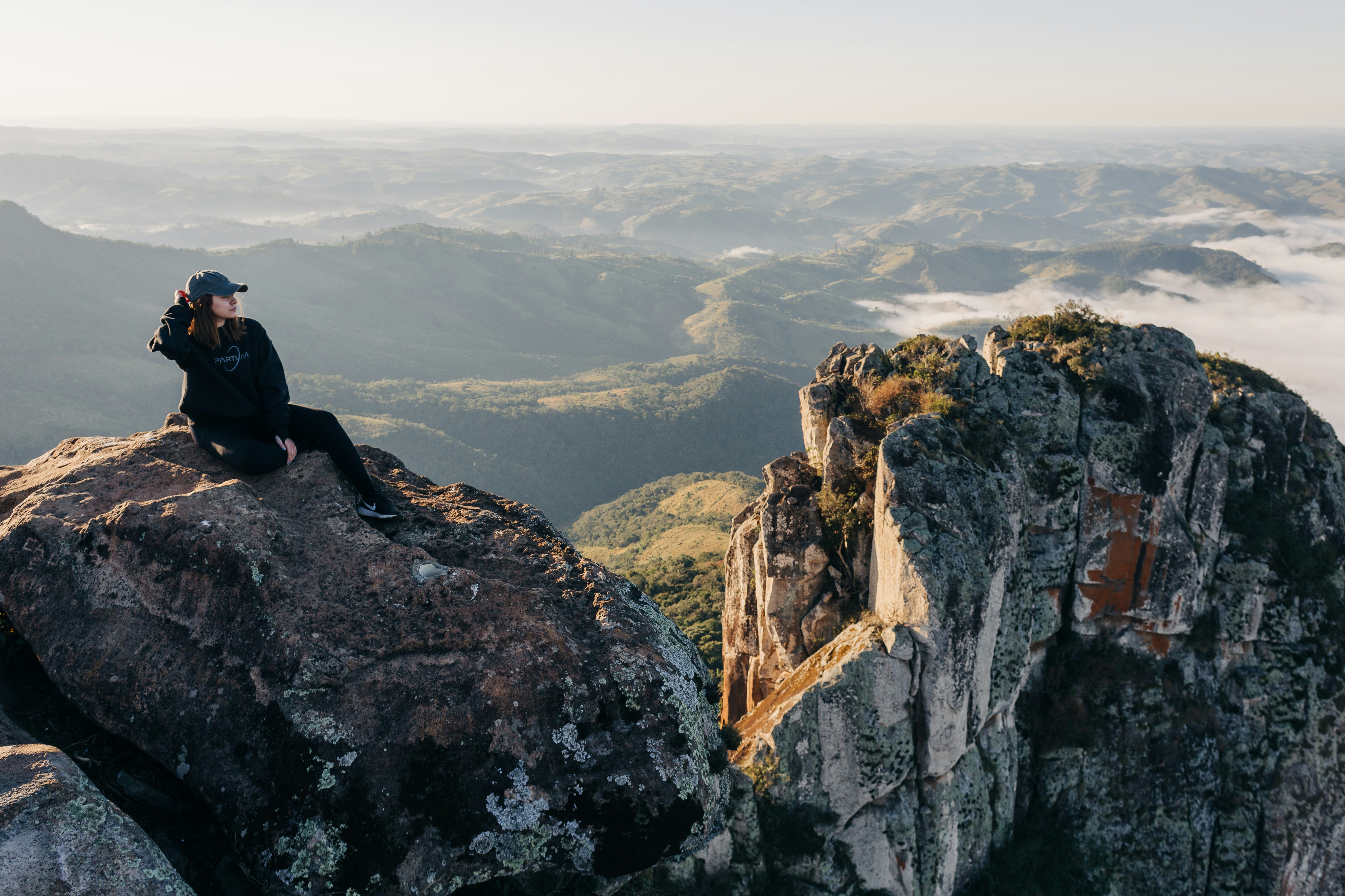 A person sitting on top of a large rock