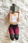 A woman laying on a bed reading a book