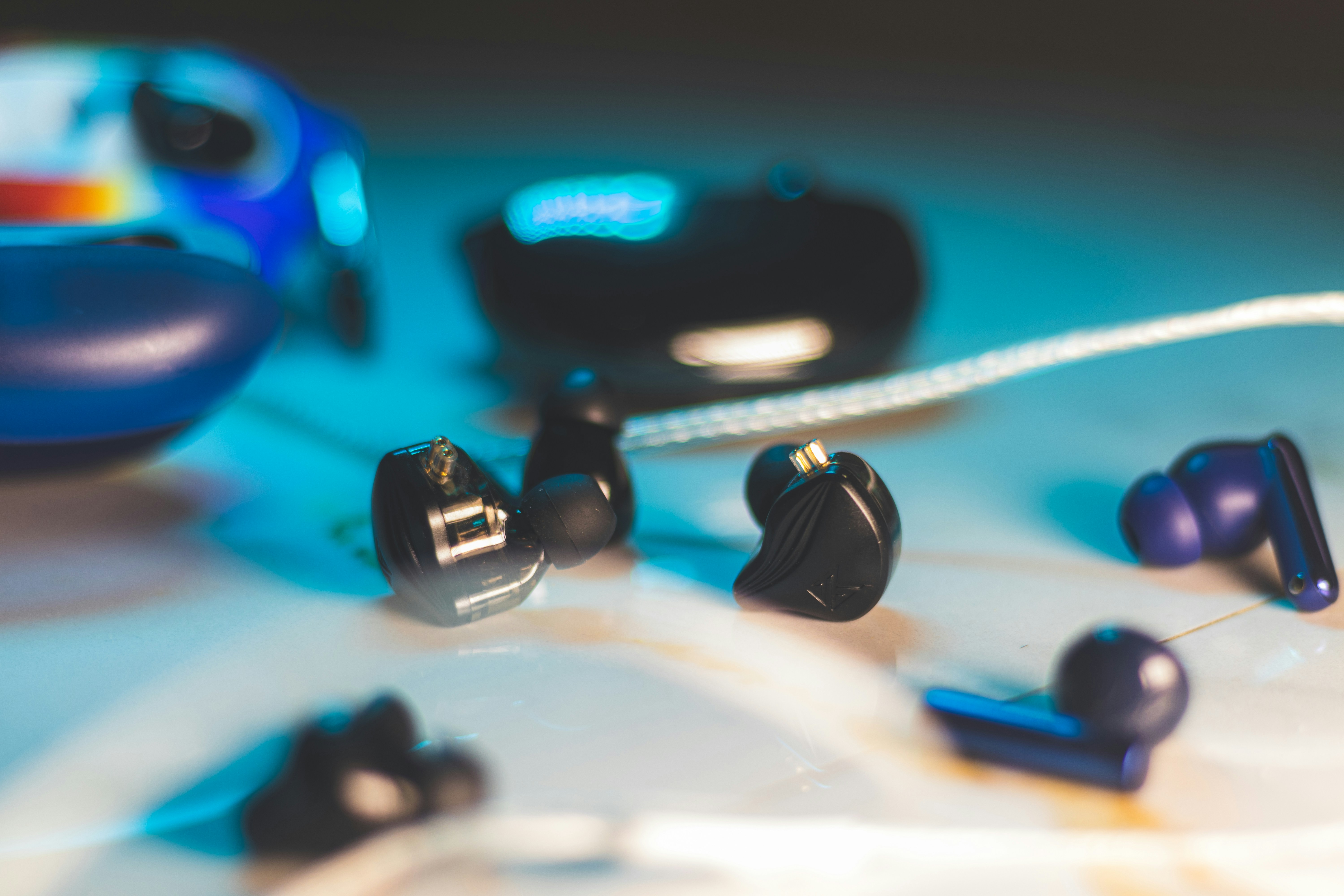 A group of ear buds laying on top of a table, 