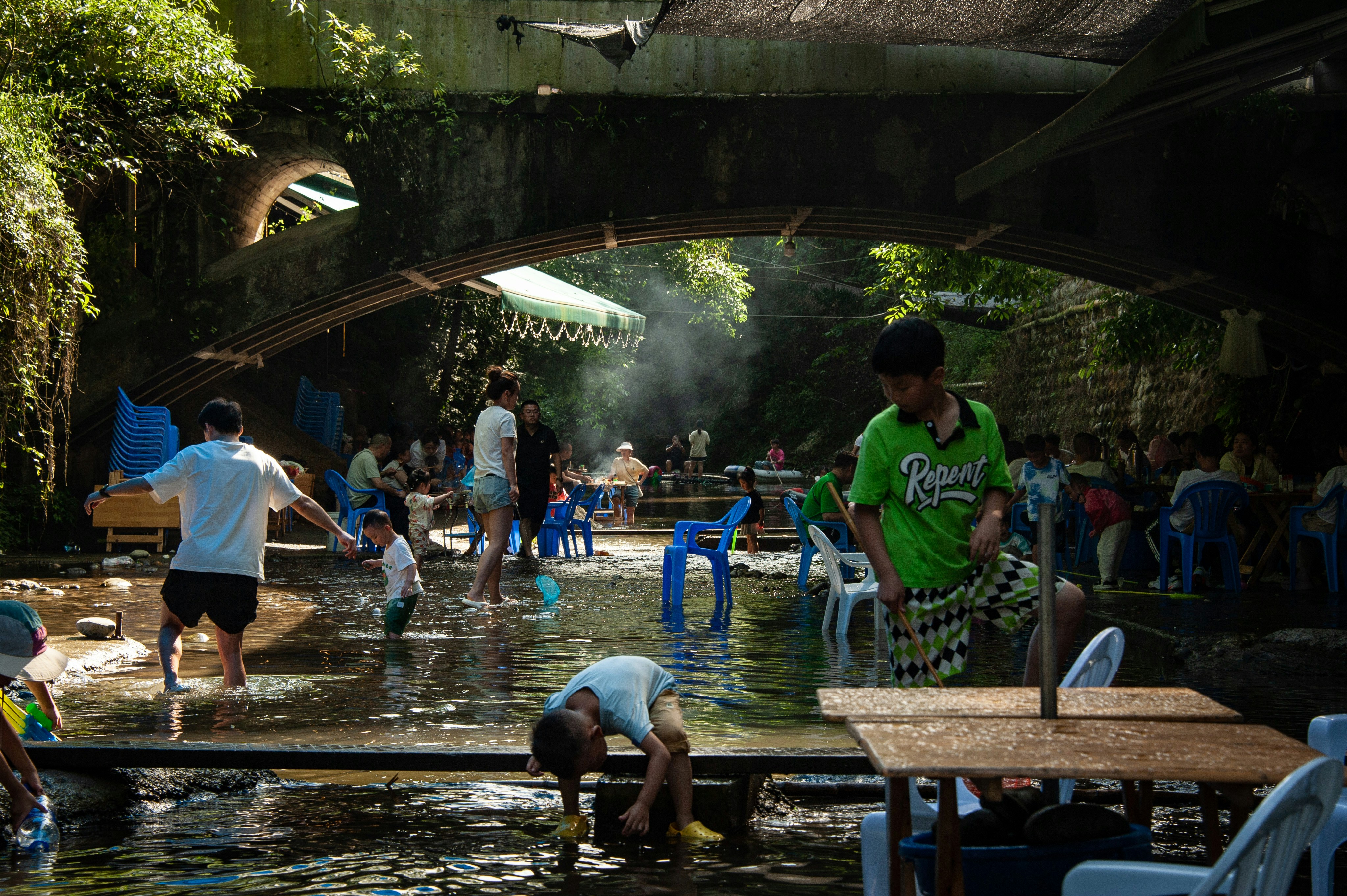 A group of people standing around a river